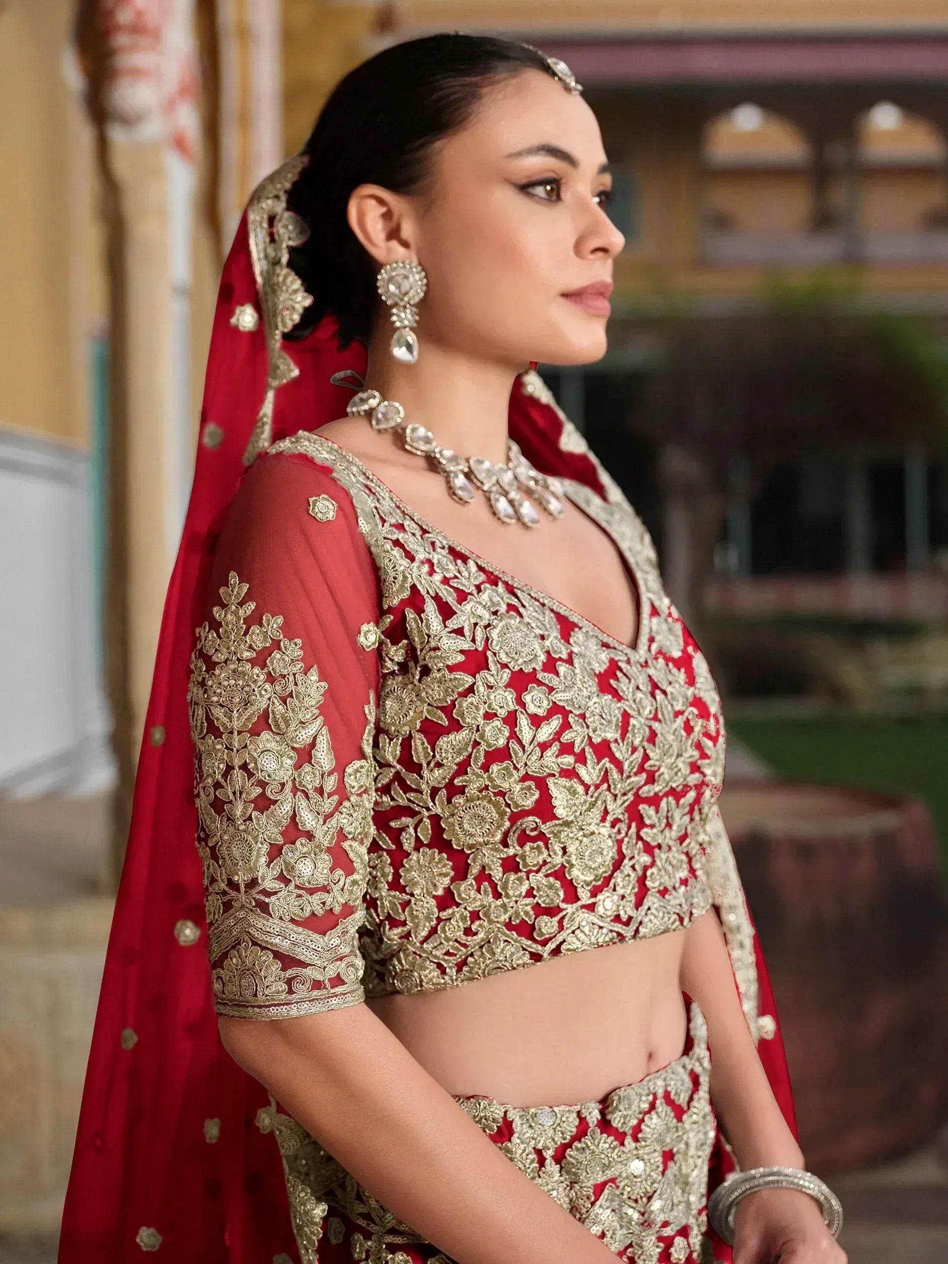 Red and gold embroidered lehenga choli with matching dupatta, perfect for Indian weddings and festive occasions.