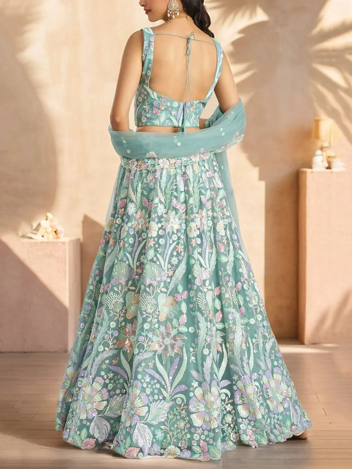 Mint green floral embroidered lehenga choli with open back blouse and dupatta, perfect for Indian ethnic wear events.