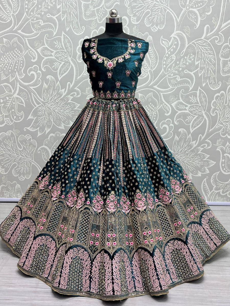 Teal velvet lehenga choli with pink floral embroidery and gold detailing, perfect for Indian ethnic wear events.