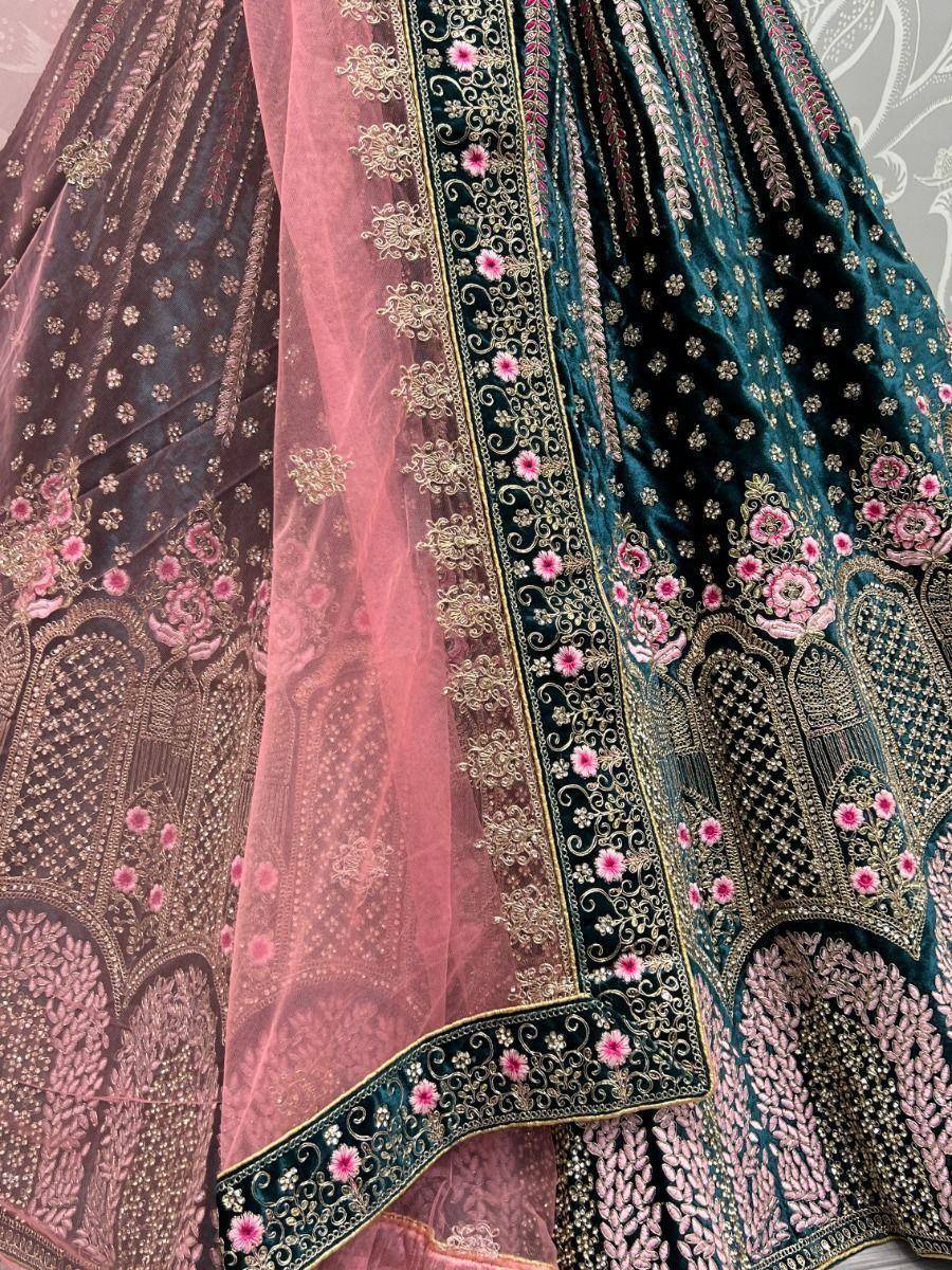 Designer lehenga choli with intricate floral embroidery and velvet fabric in teal and pink hues