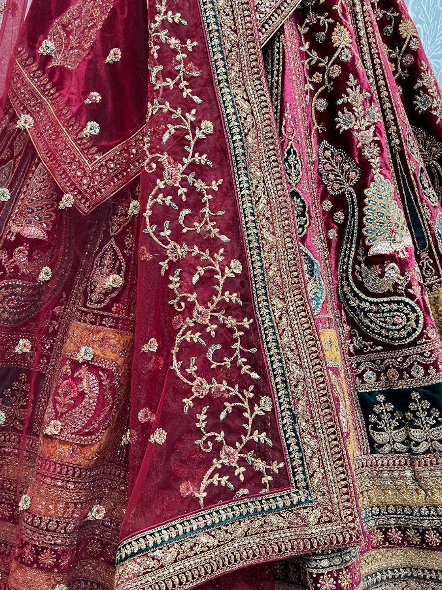 Rich maroon velvet lehenga with intricate gold embroidery and peacock motifs, perfect for Indian weddings.