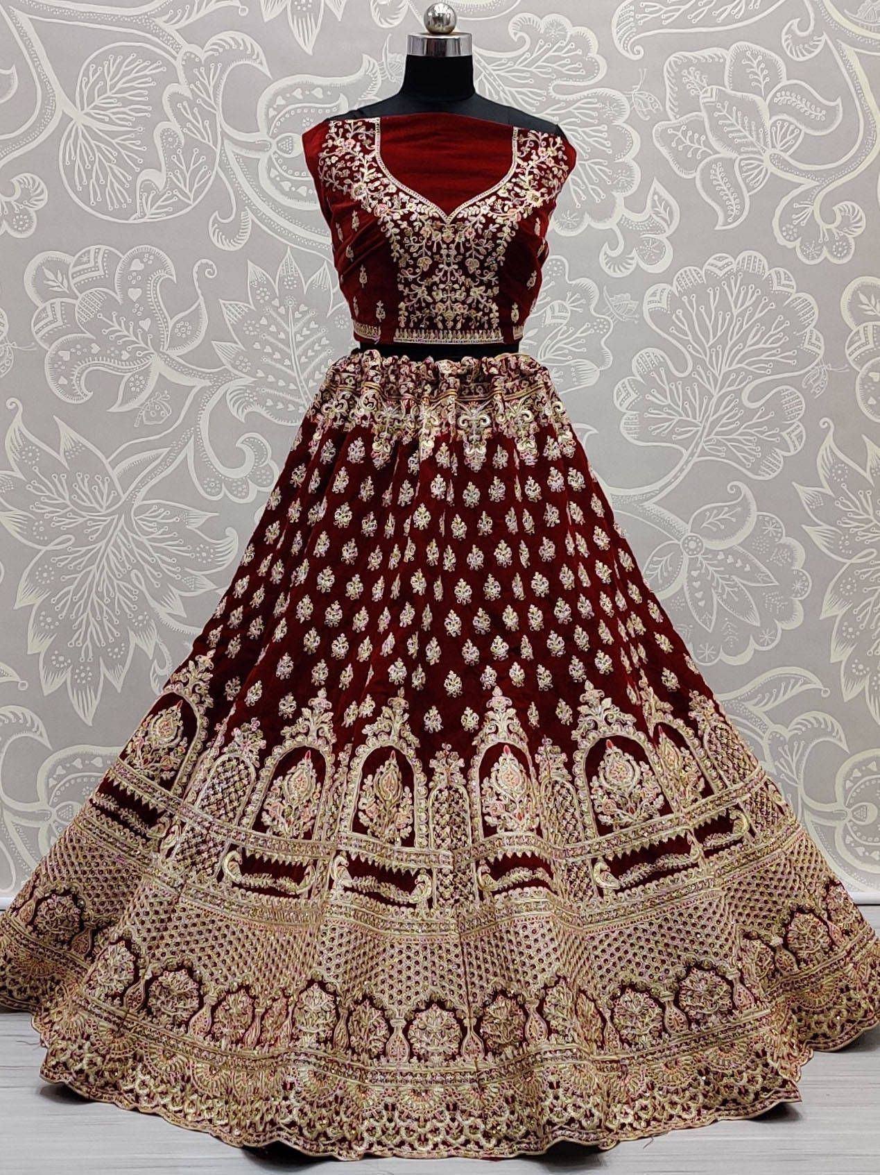 Maroon velvet lehenga choli with heavy gold embroidery, perfect for Indian weddings and festive occasions.