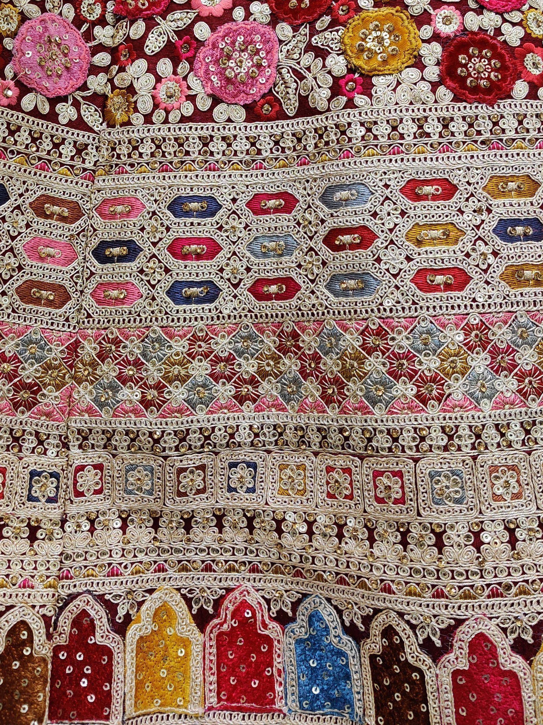 Intricate floral and geometric embroidery with sequins on Indian ethnic wear fabric, perfect for lehenga or saree.