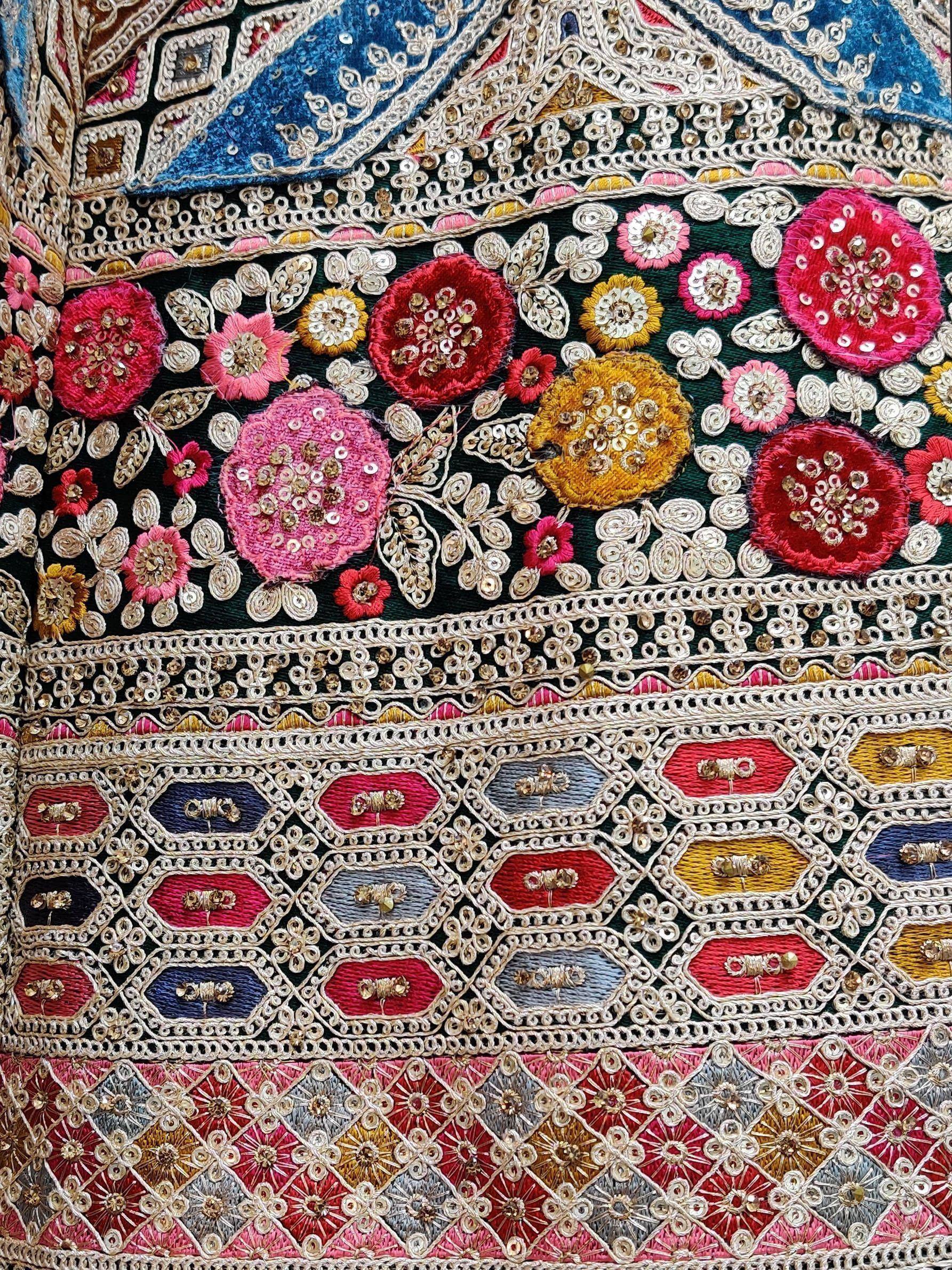 Vibrant floral embroidery with sequins on Indian ethnic wear, featuring intricate zari work and colorful patterns.