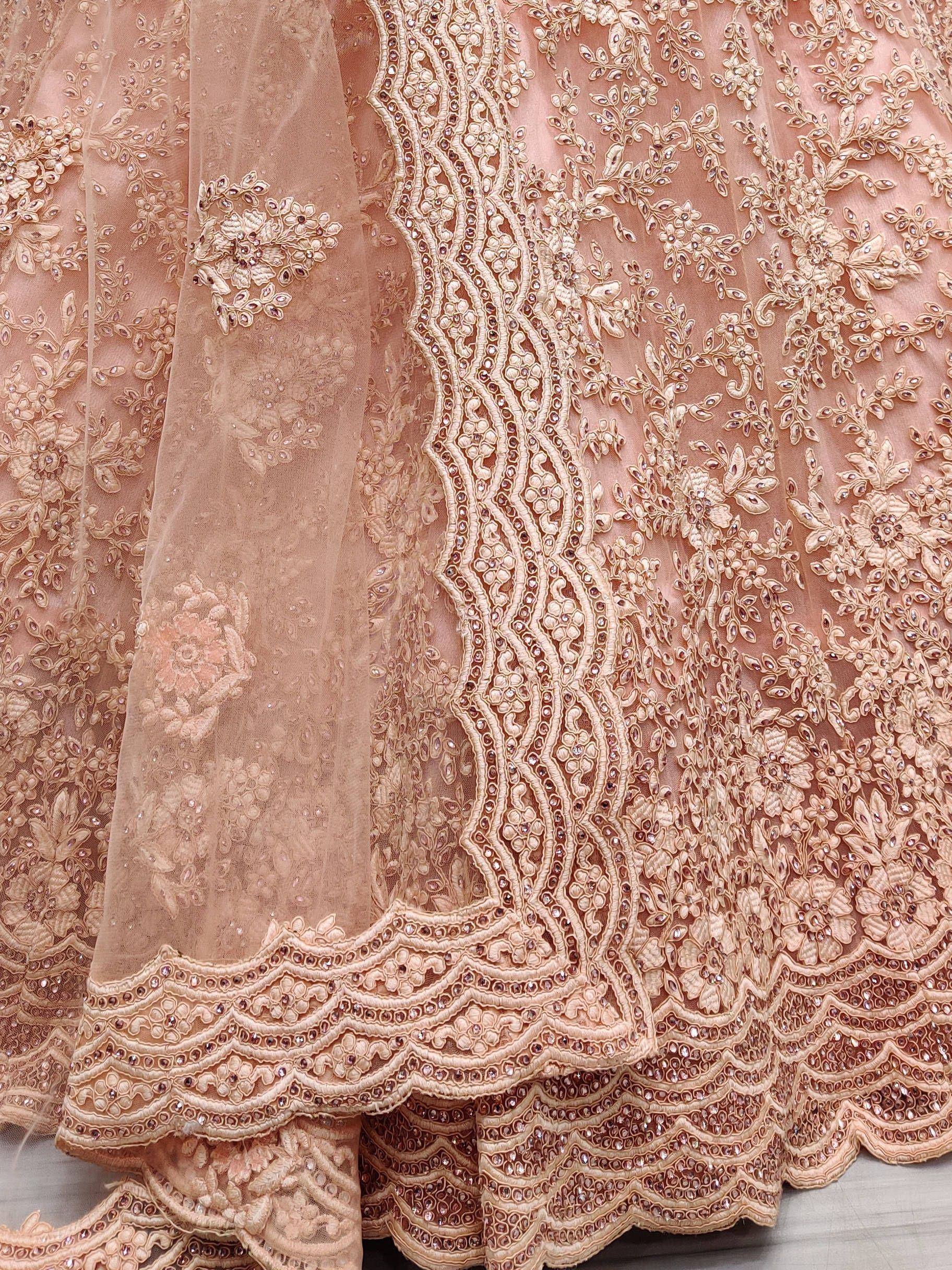 Elegant peach lehenga with intricate floral embroidery and sequin detailing for Indian ethnic wear