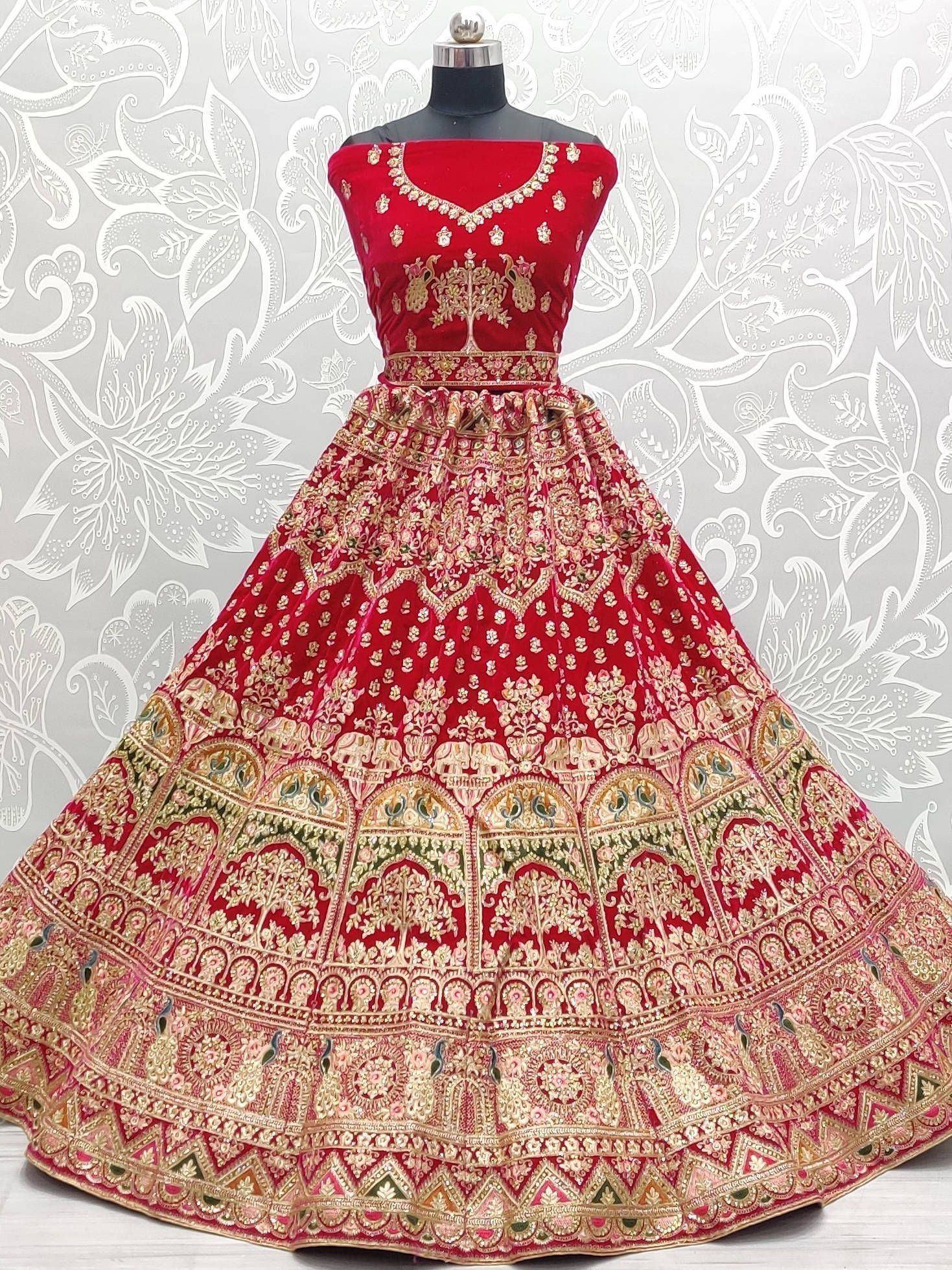 Red velvet designer lehenga choli with heavy gold embroidery and floral motifs, perfect for weddings