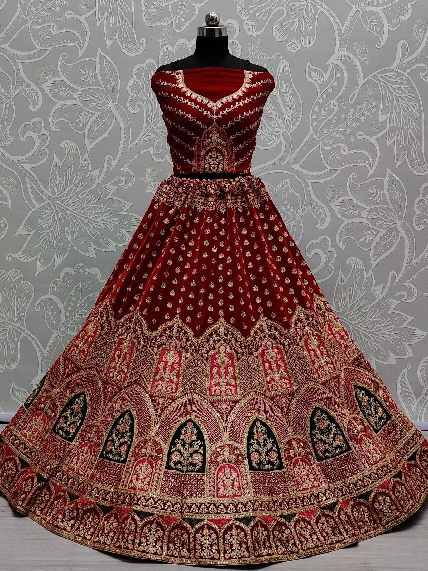 Red velvet designer lehenga choli with gold embroidery, perfect for Indian weddings and festive occasions.
