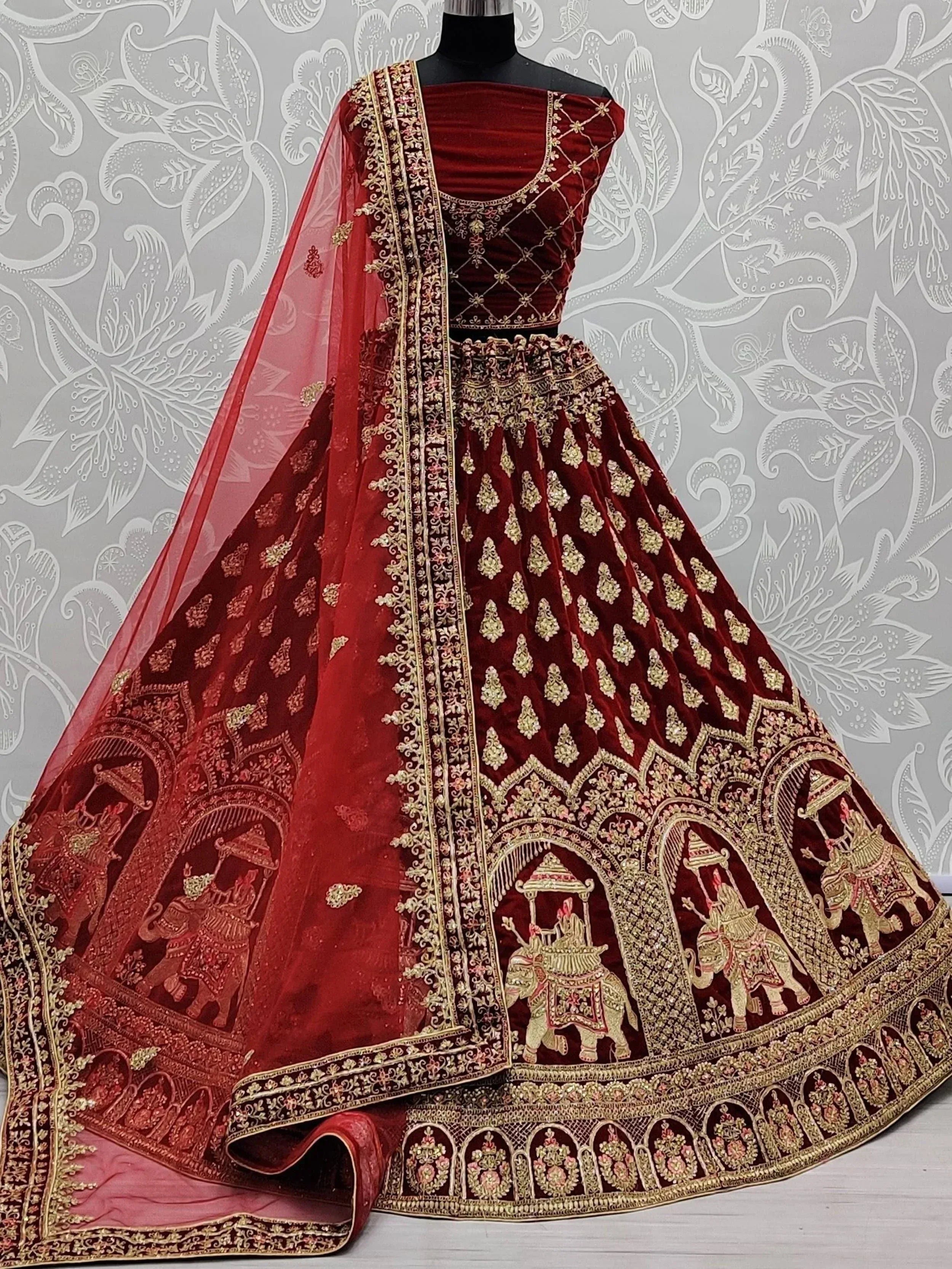 Maroon velvet lehenga choli with gold embroidery and elephant motifs, perfect for Indian weddings and festive occasions.