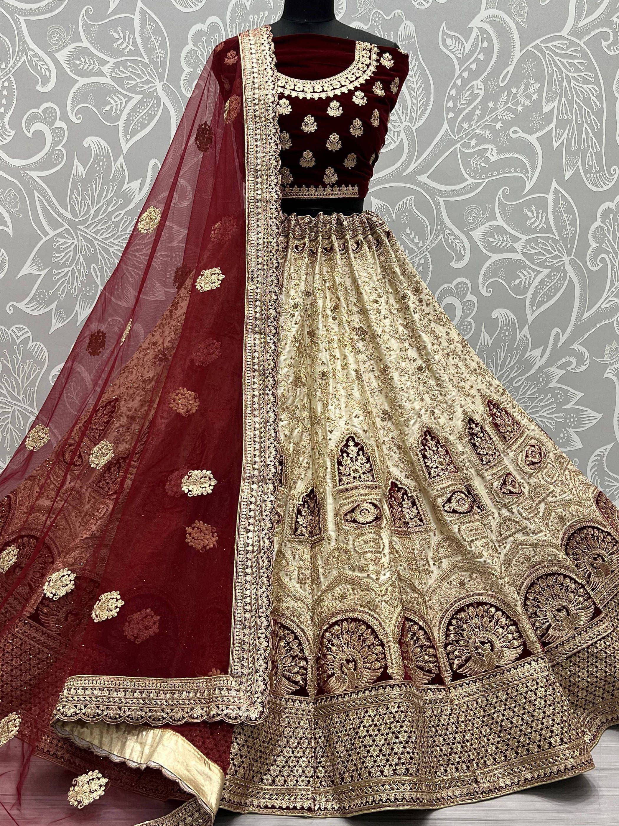 Maroon velvet blouse with gold embroidery, cream lehenga, and matching dupatta for Indian ethnic wear