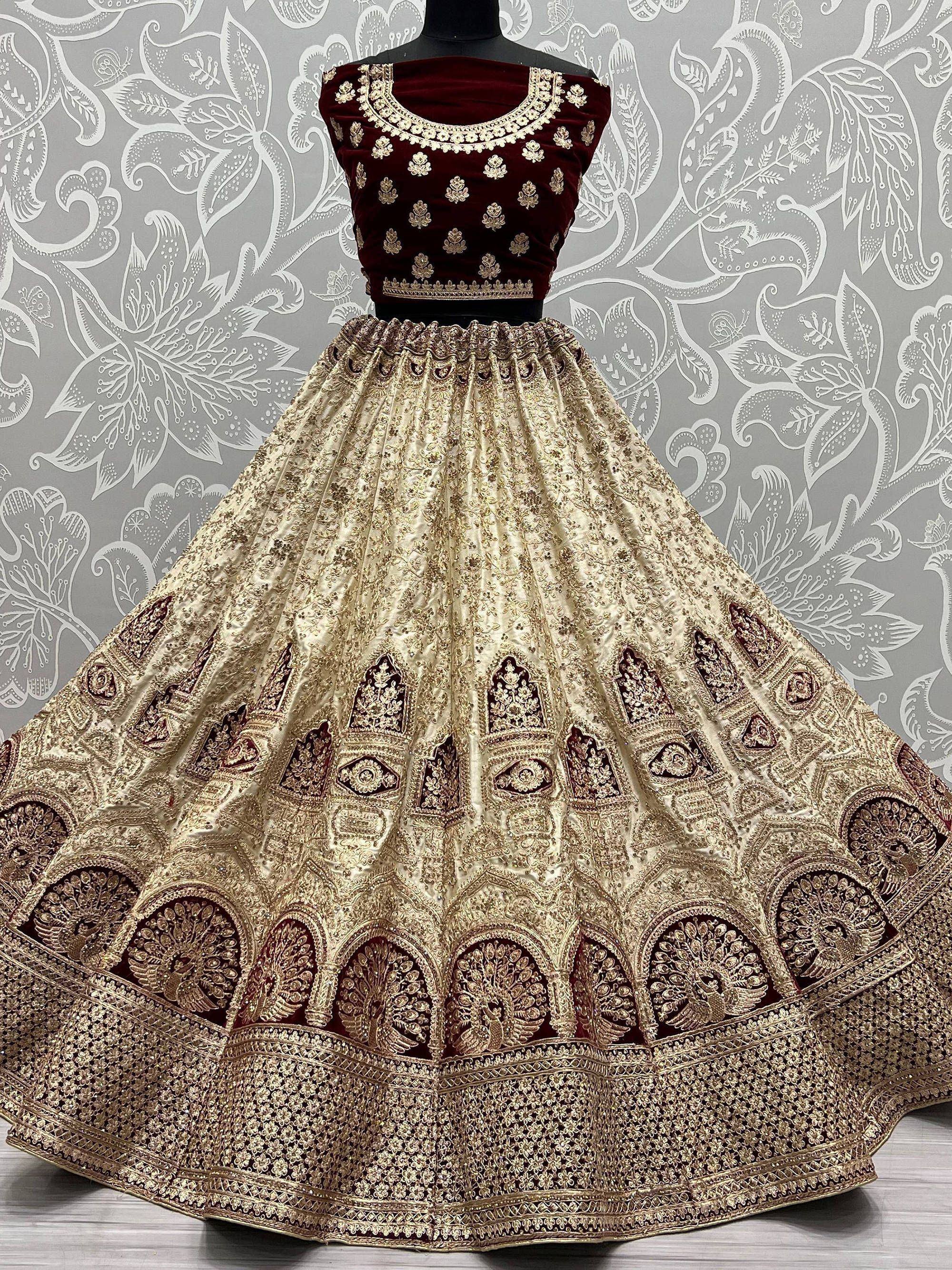 Maroon velvet blouse with gold embroidery paired with a heavily embellished cream lehenga, perfect for Indian ethnic wear.