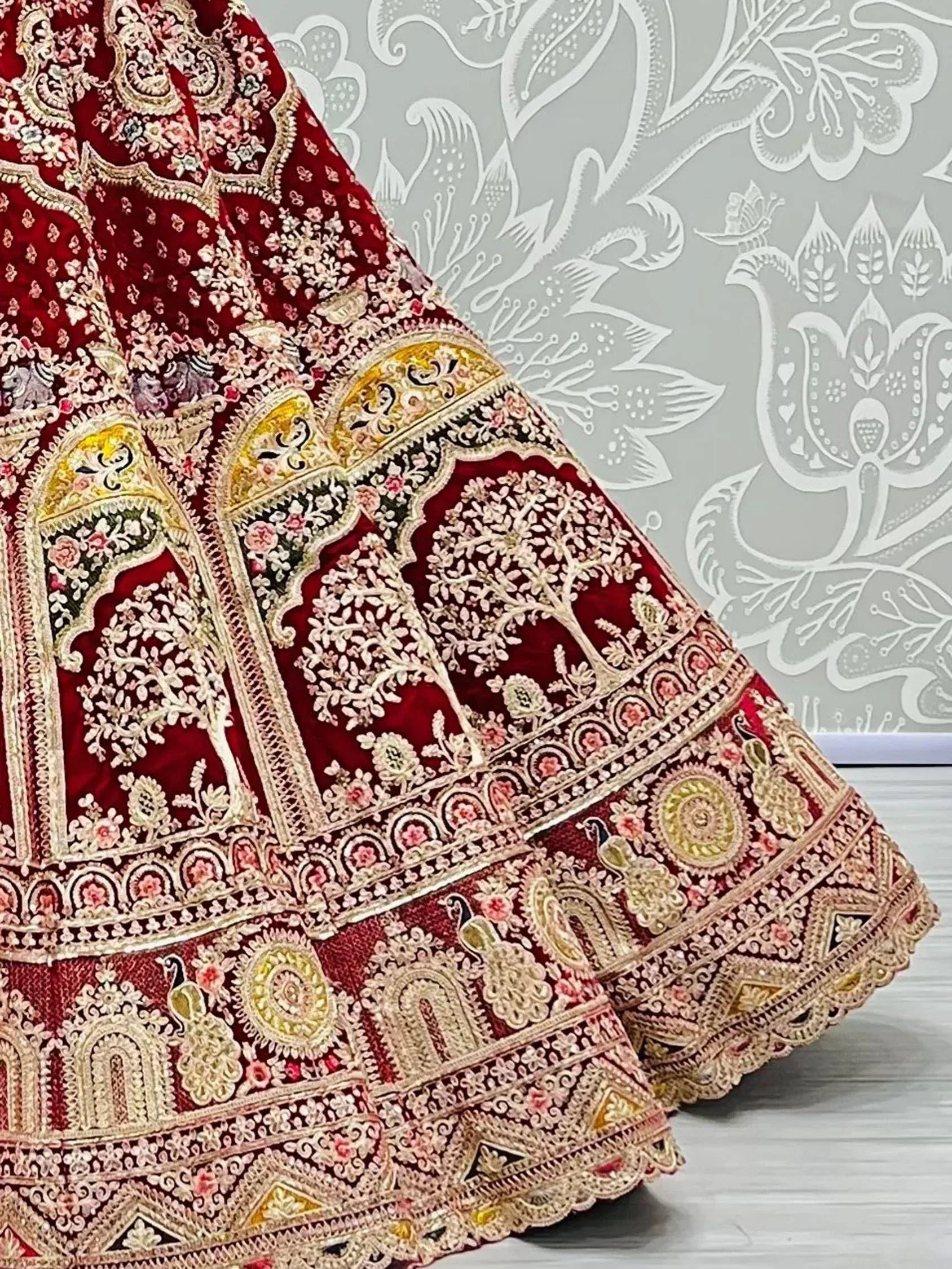 Luxury red velvet lehenga with intricate gold embroidery, floral motifs, and peacock designs for Indian ethnic wear.