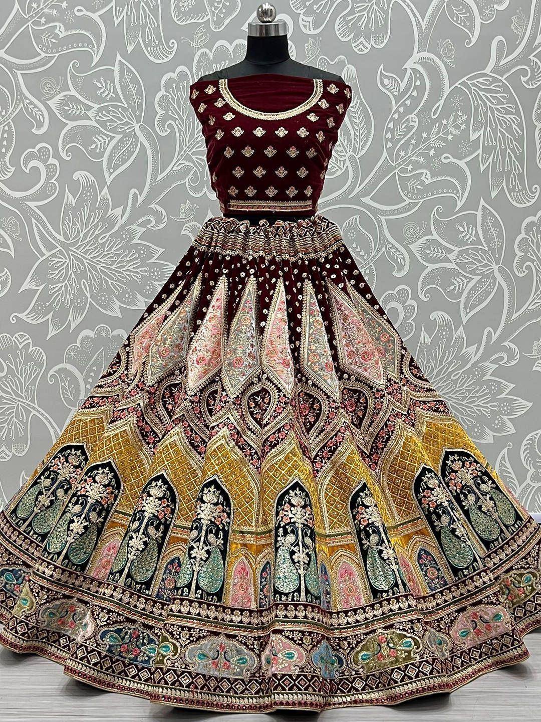 Maroon velvet designer lehenga choli with intricate gold and floral embroidery, perfect for Indian weddings and festive occasions.