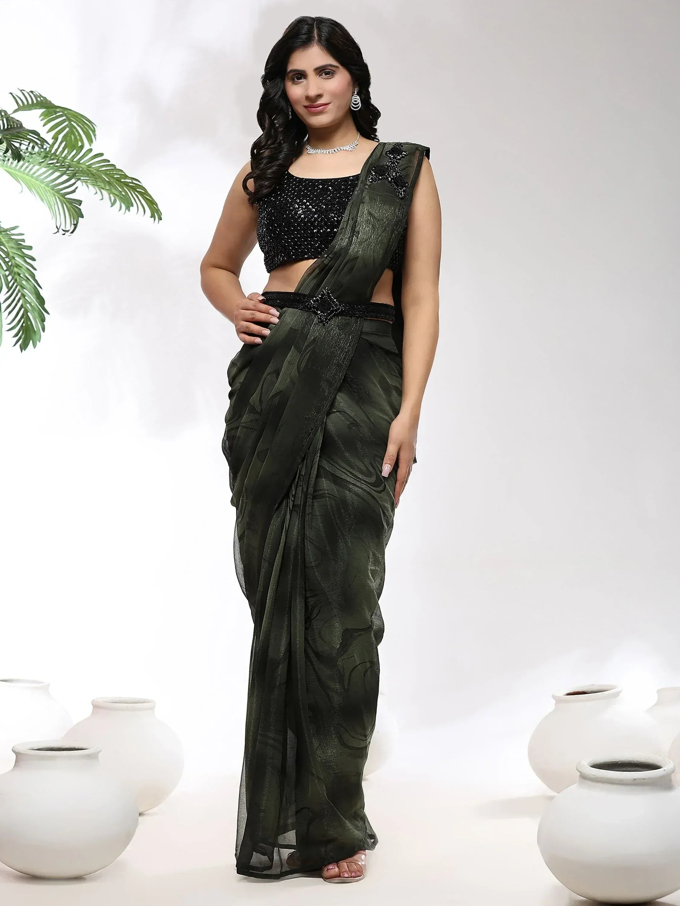 Woman in olive green designer saree with black sequin blouse, perfect for ethnic occasions