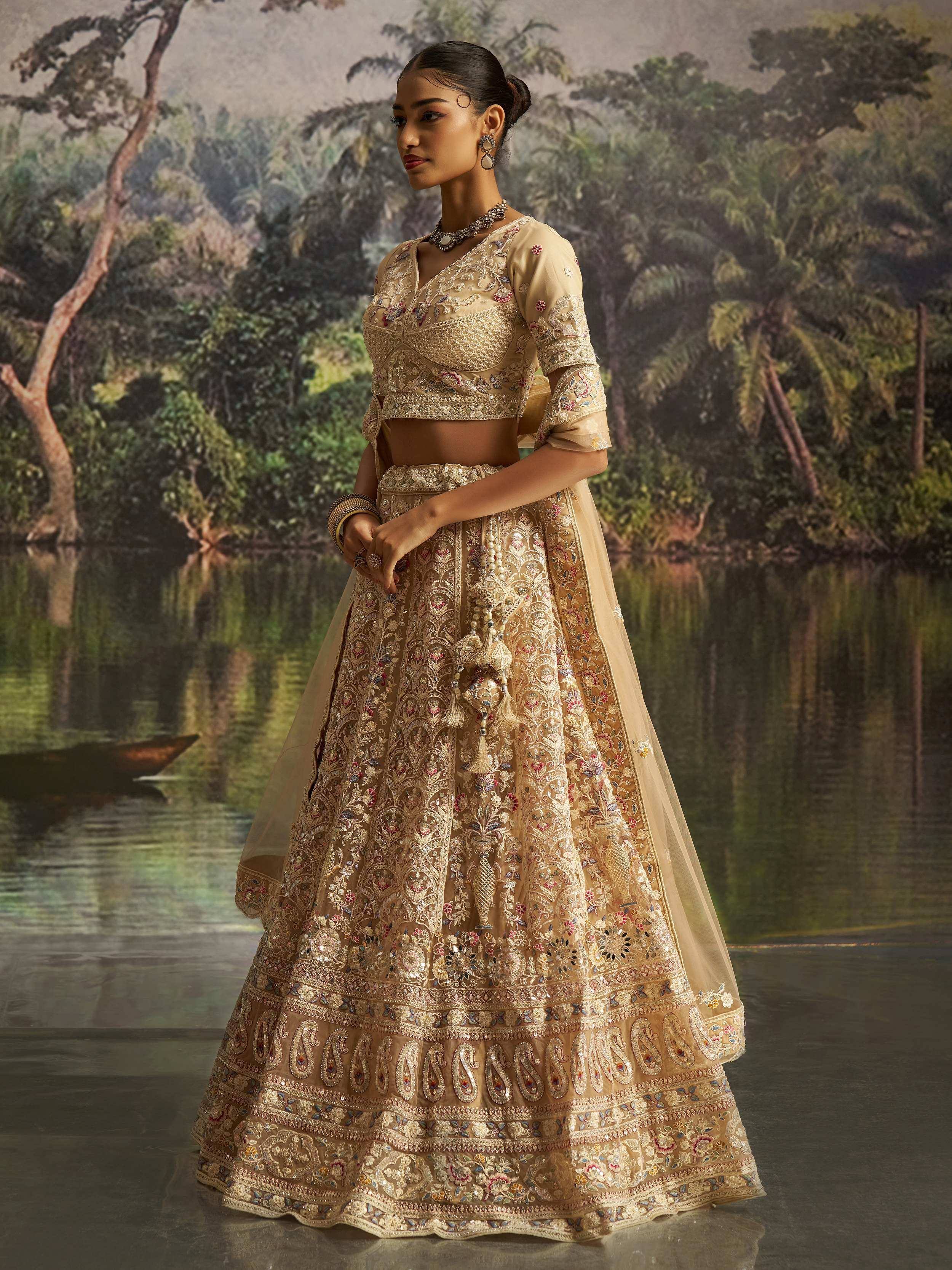 Elegant beige embroidered lehenga choli with floral motifs, perfect for Indian weddings and festive occasions.