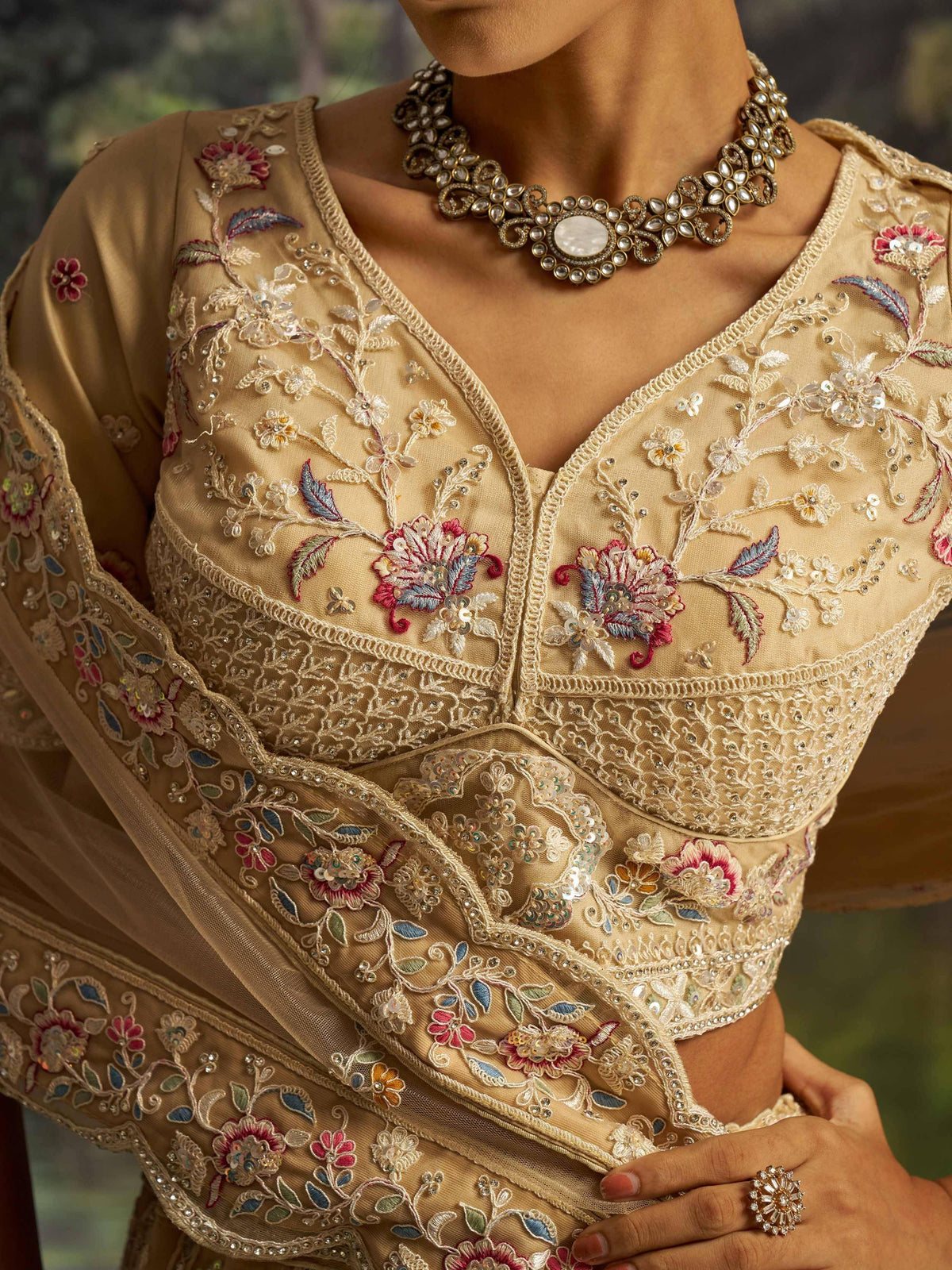 Beige floral embroidered lehenga choli with sequins and traditional jewelry