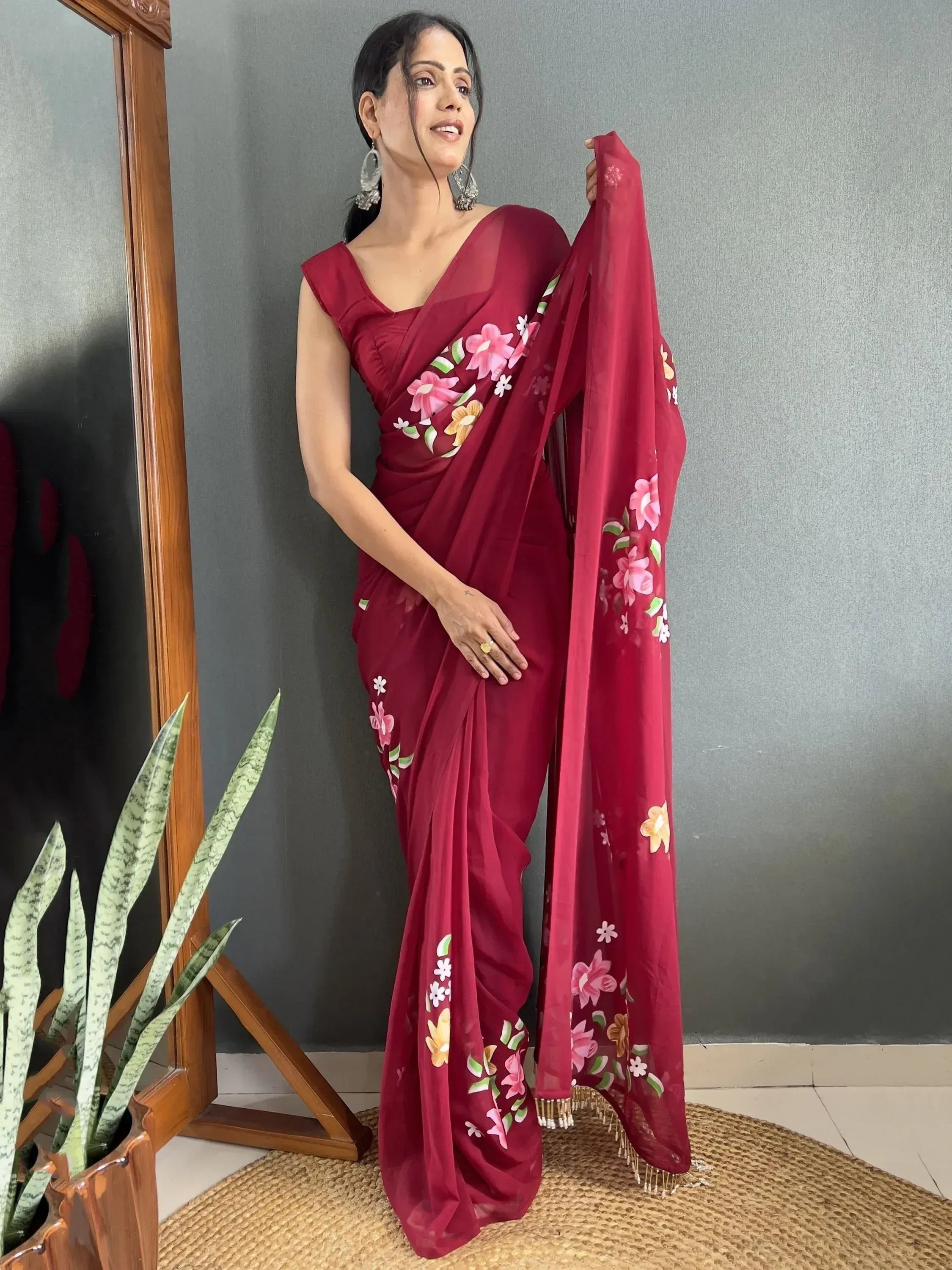 Woman in maroon floral saree with embroidered border, stylish ethnic wear for women