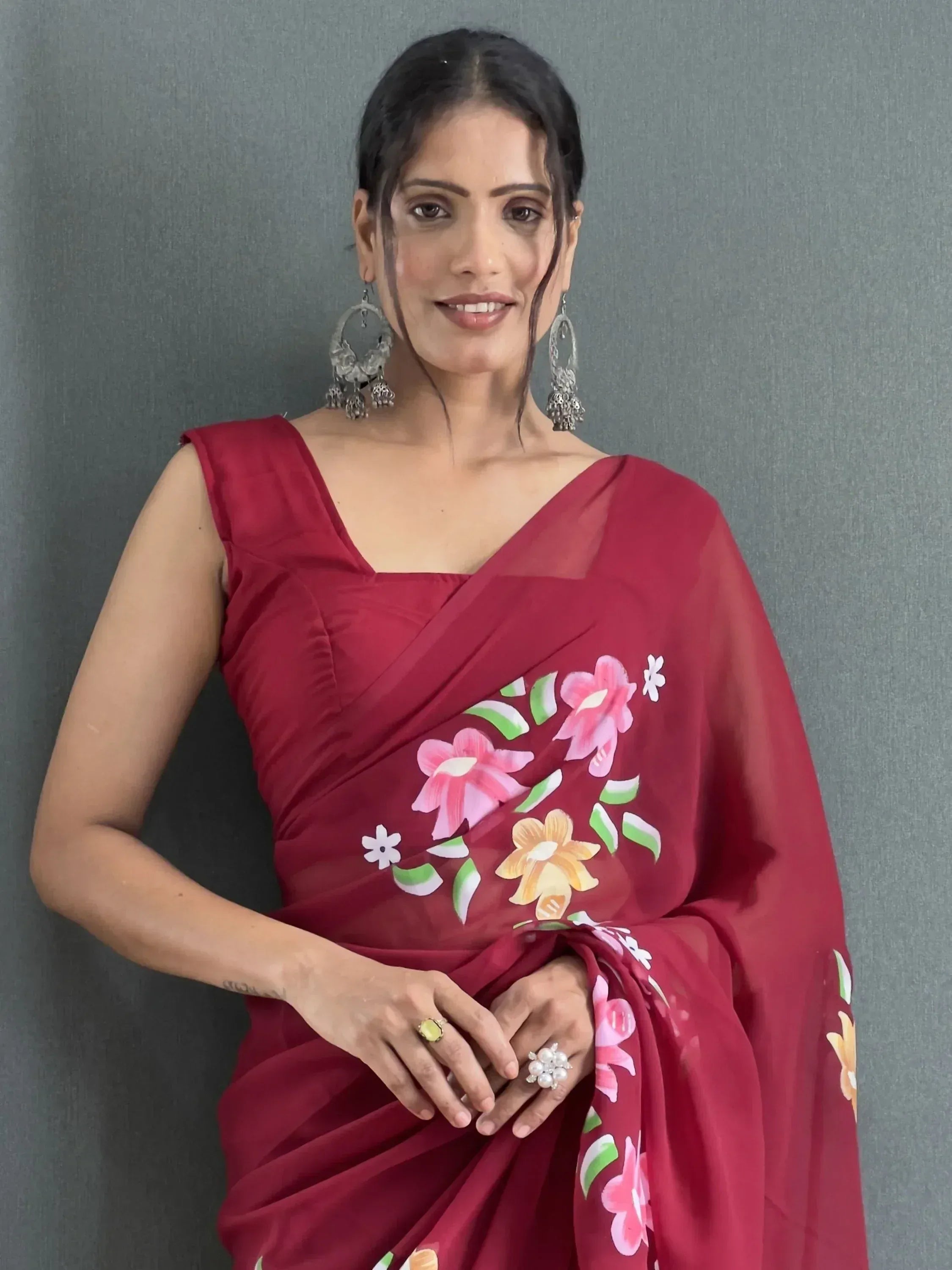 Woman in maroon floral saree with ethnic jewelry, stylish Indian ethnic wear