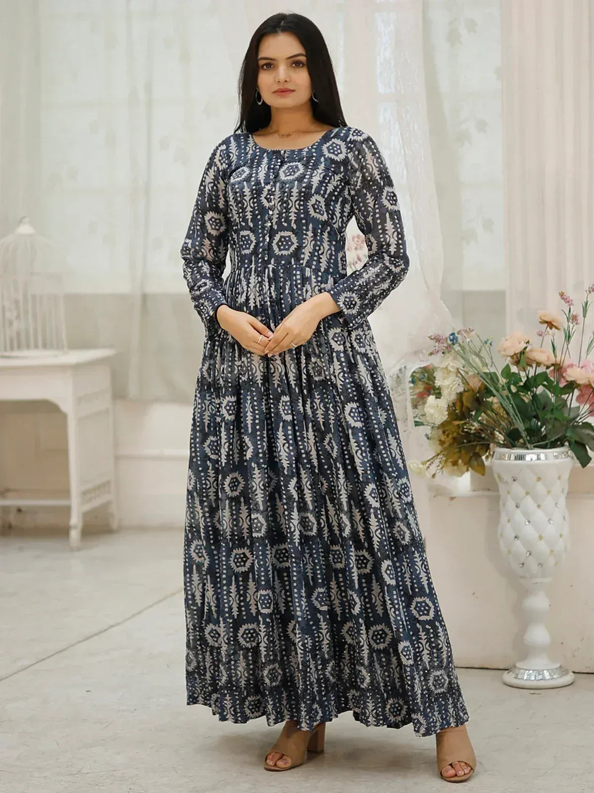 Woman in navy blue printed ethnic gown with long sleeves, ideal for Indian occasions and festive wear.