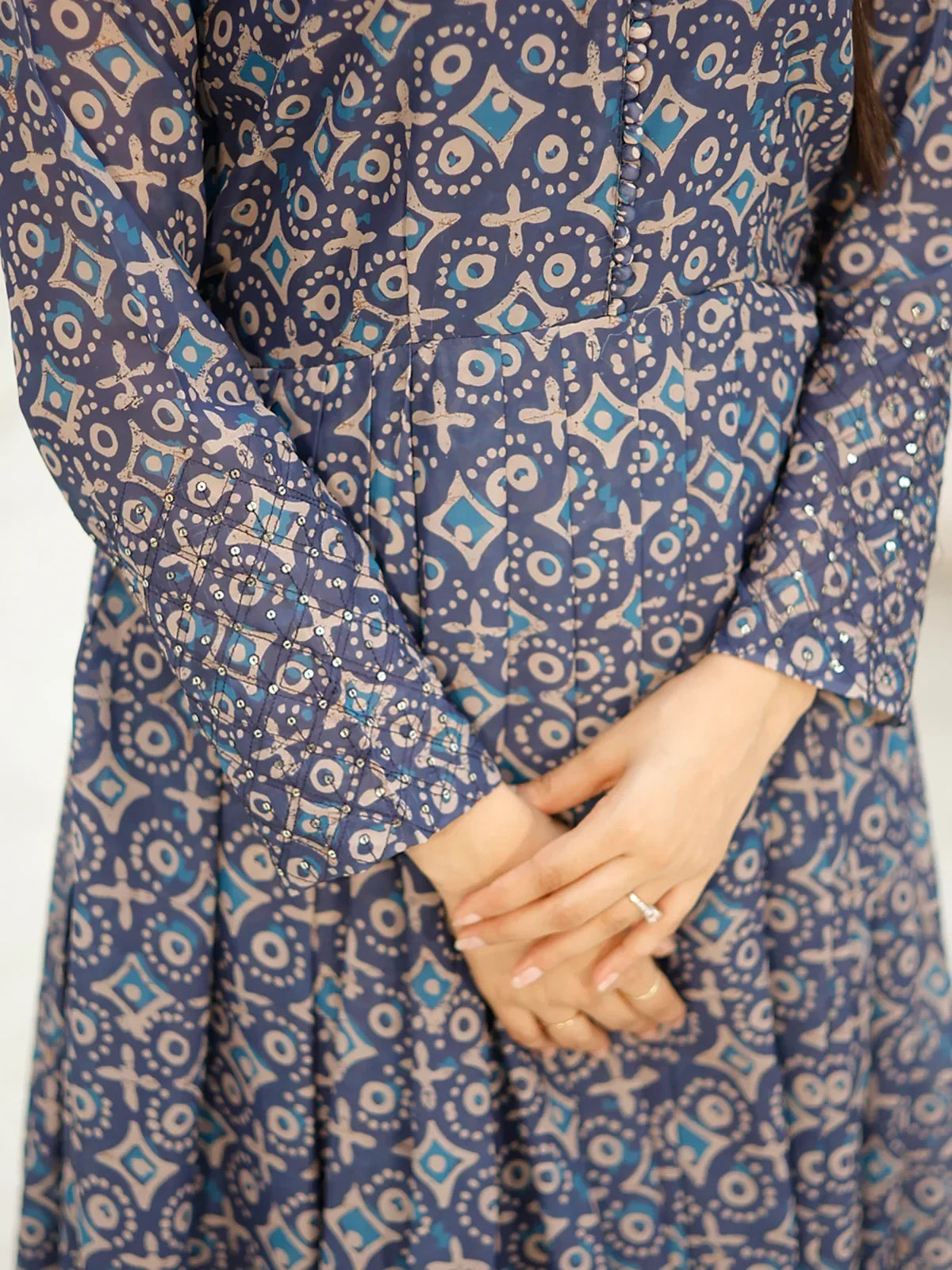 Close-up of woman wearing blue and beige printed ethnic gown with geometric patterns