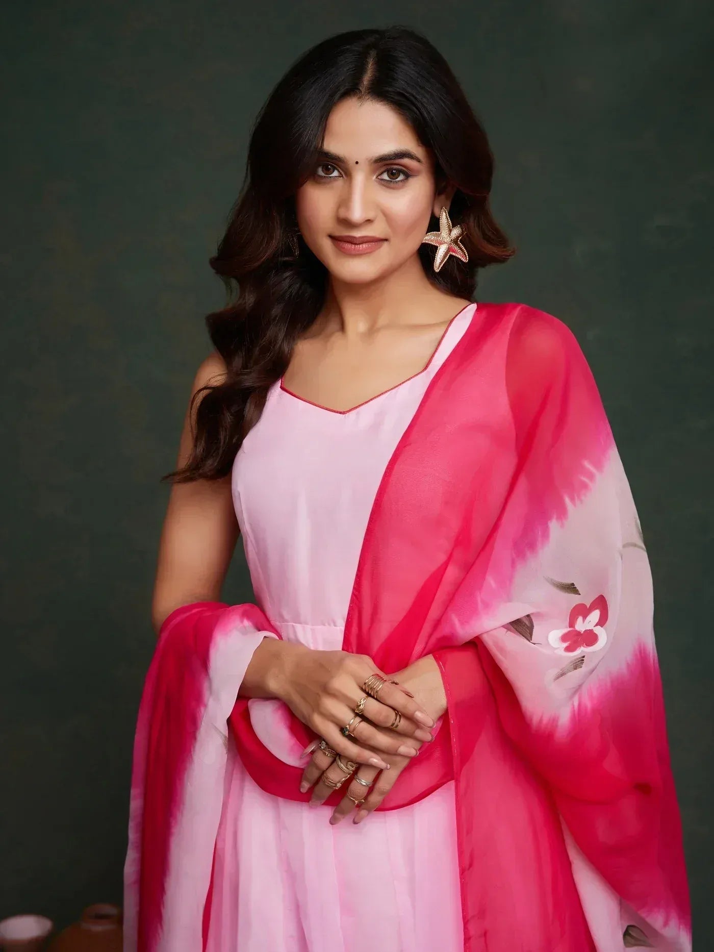 Woman in pink ethnic gown with floral dupatta, perfect for Indian occasions and festive wear.