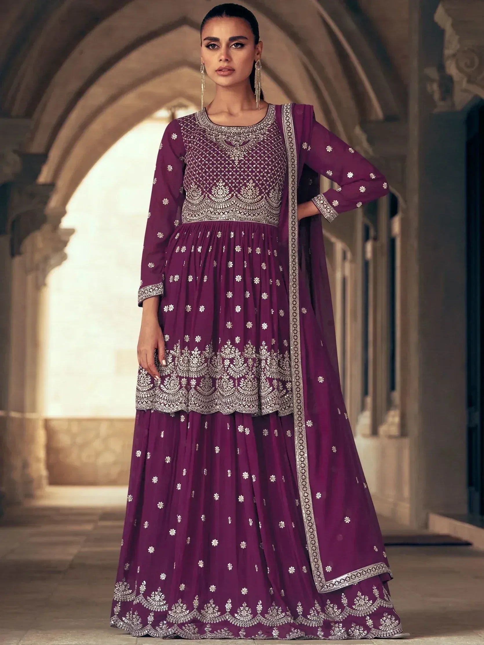 Elegant purple ethnic gown with intricate silver embroidery and floral patterns, perfect for festive occasions.
