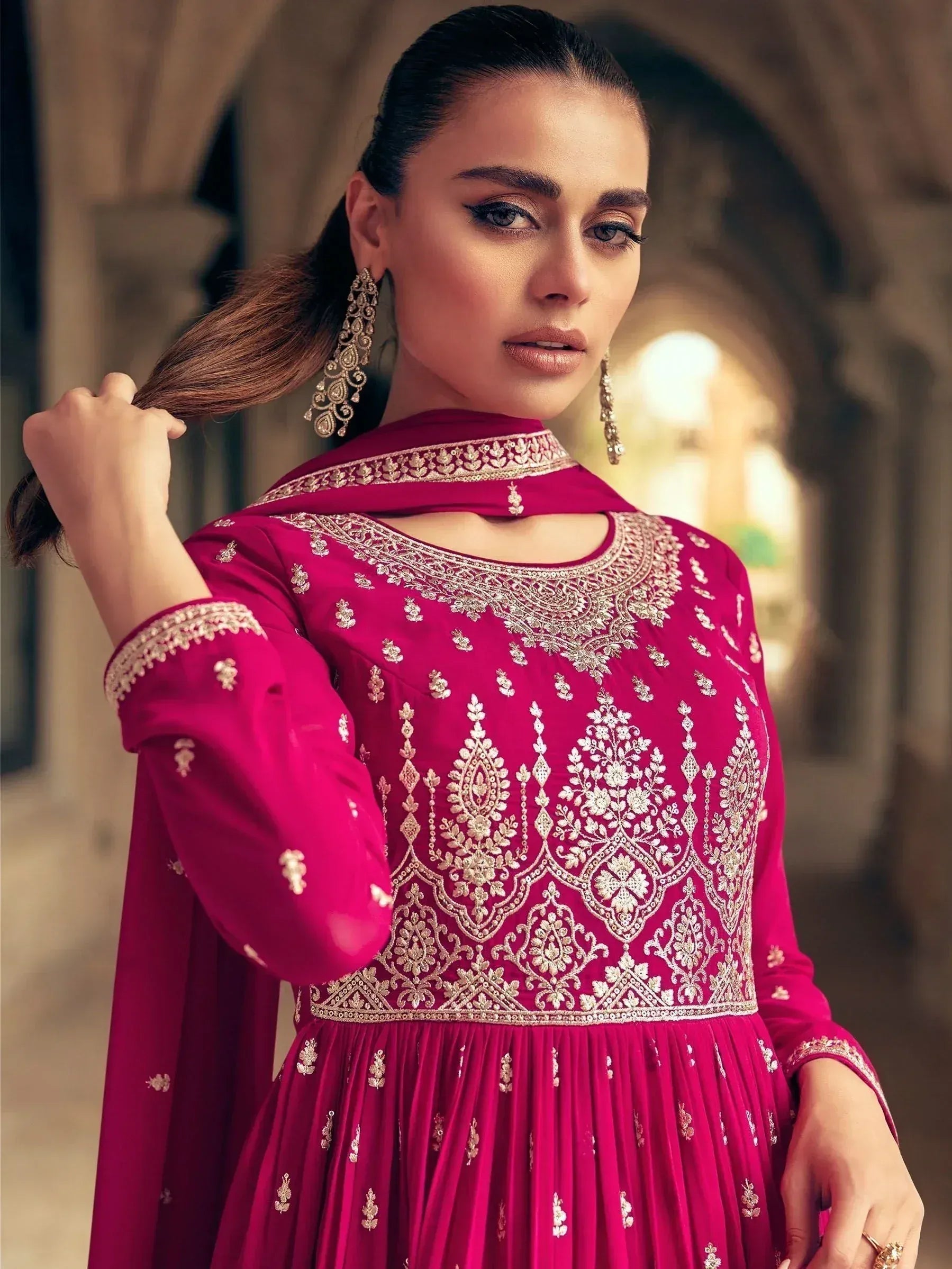 Elegant magenta ethnic gown with gold embroidery, perfect for Indian celebrations and weddings.