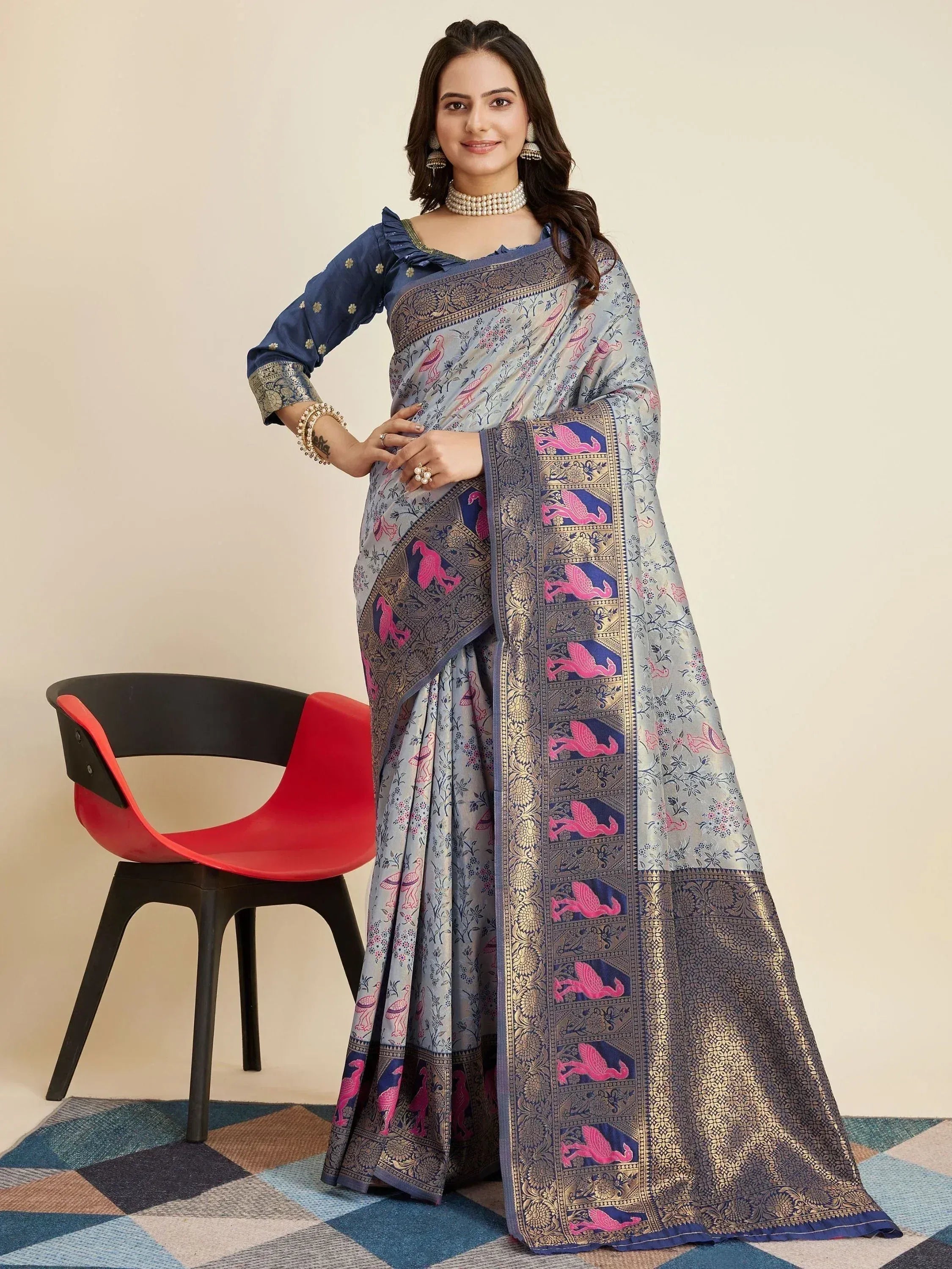 Woman in elegant blue saree with pink bird print and gold border, paired with matching blouse, perfect for Indian ethnic occasions.