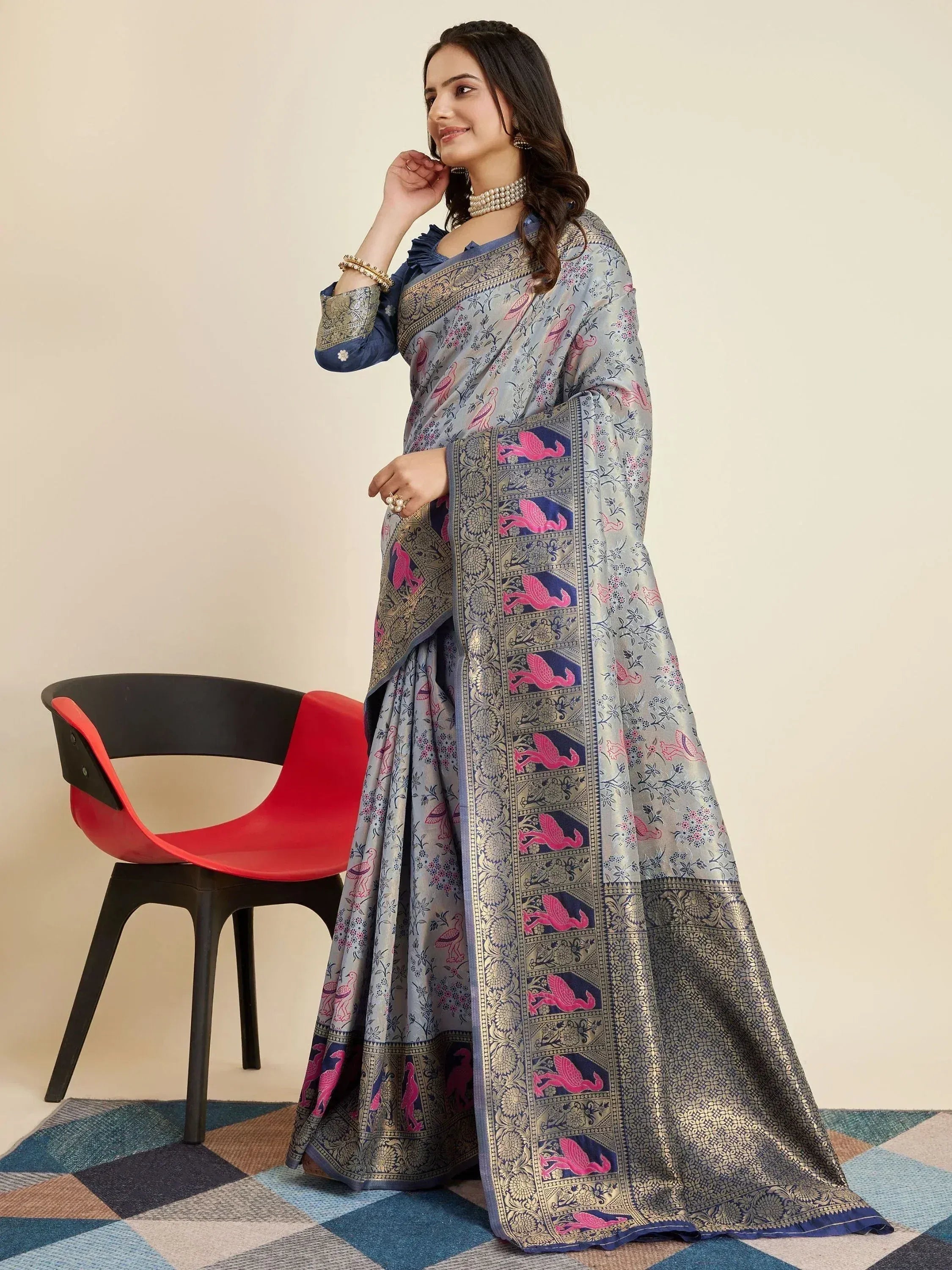 Woman in elegant grey saree with pink bird print and gold border, paired with blue blouse, ideal for ethnic occasions