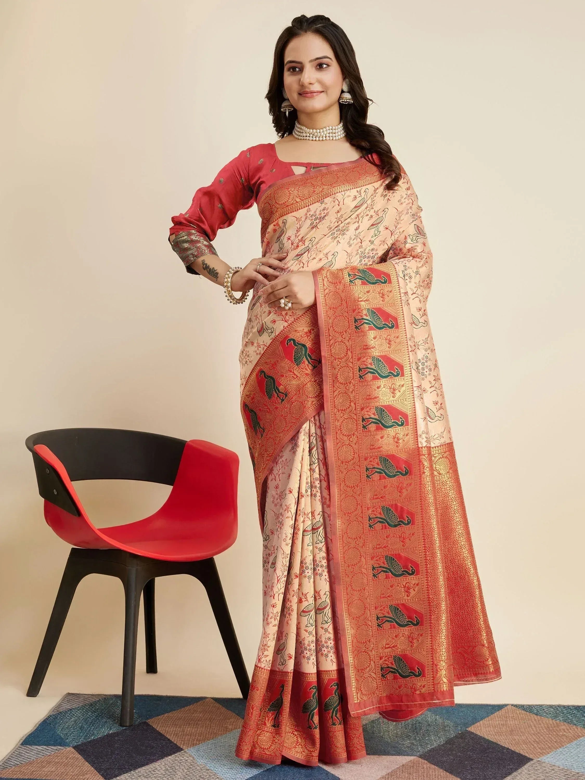 Woman in elegant peach saree with bird print and red border, paired with matching blouse, perfect for Indian ethnic occasions