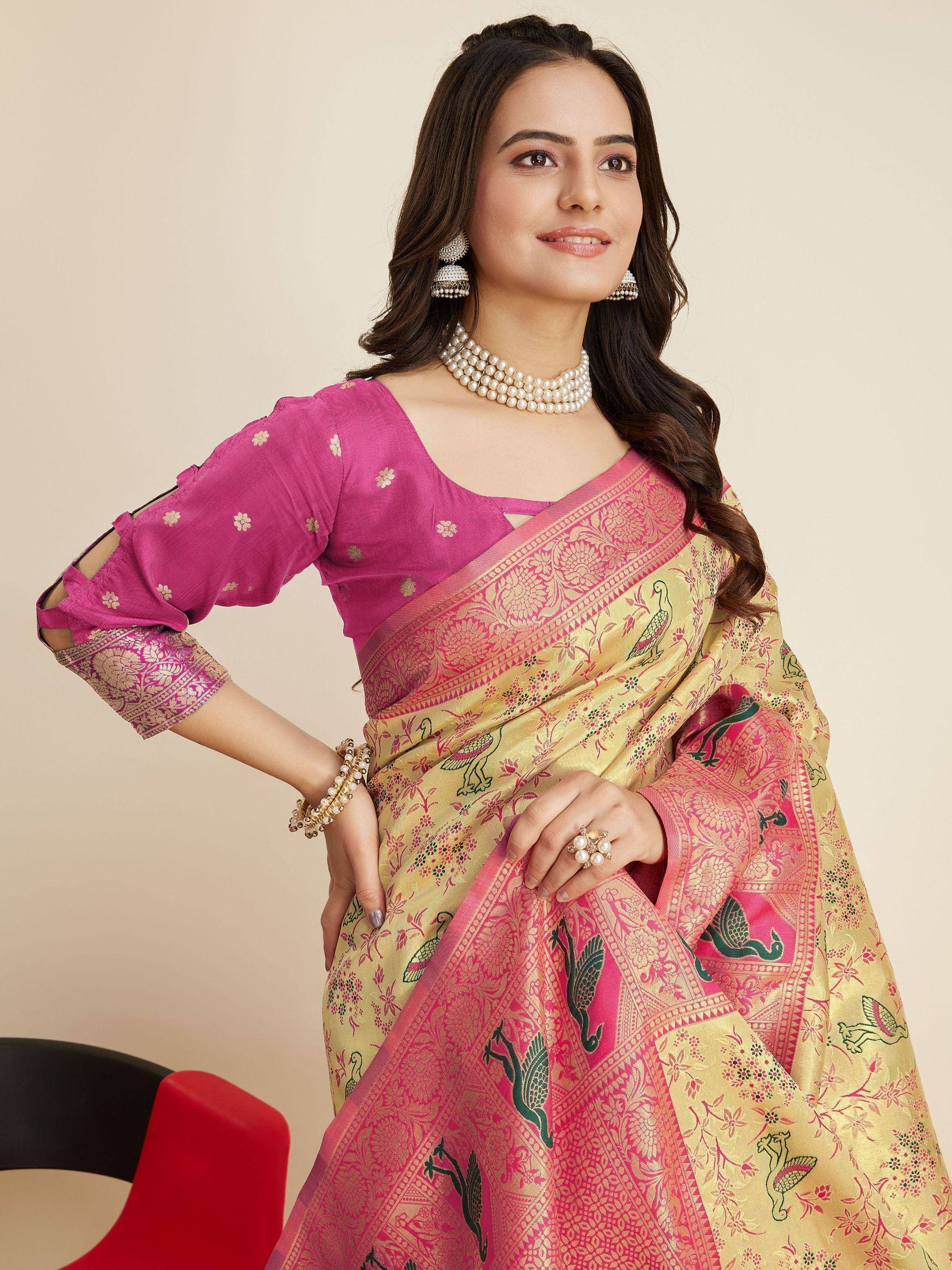 Woman in pink and gold Banarasi saree with peacock print, paired with matching blouse and pearl jewelry