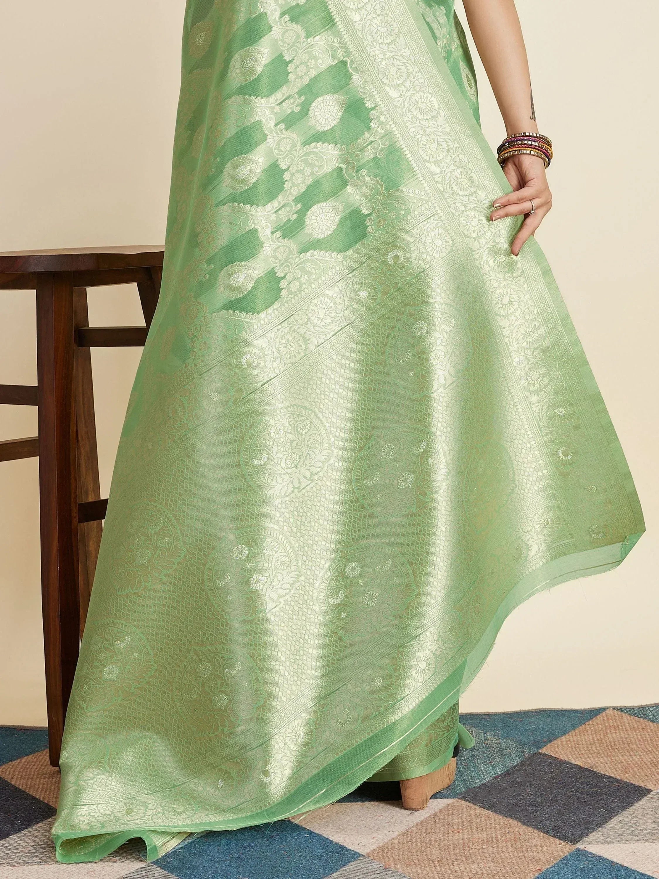 Mint green designer ethnic gown with intricate gold paisley and floral jacquard patterns, perfect for festive occasions.