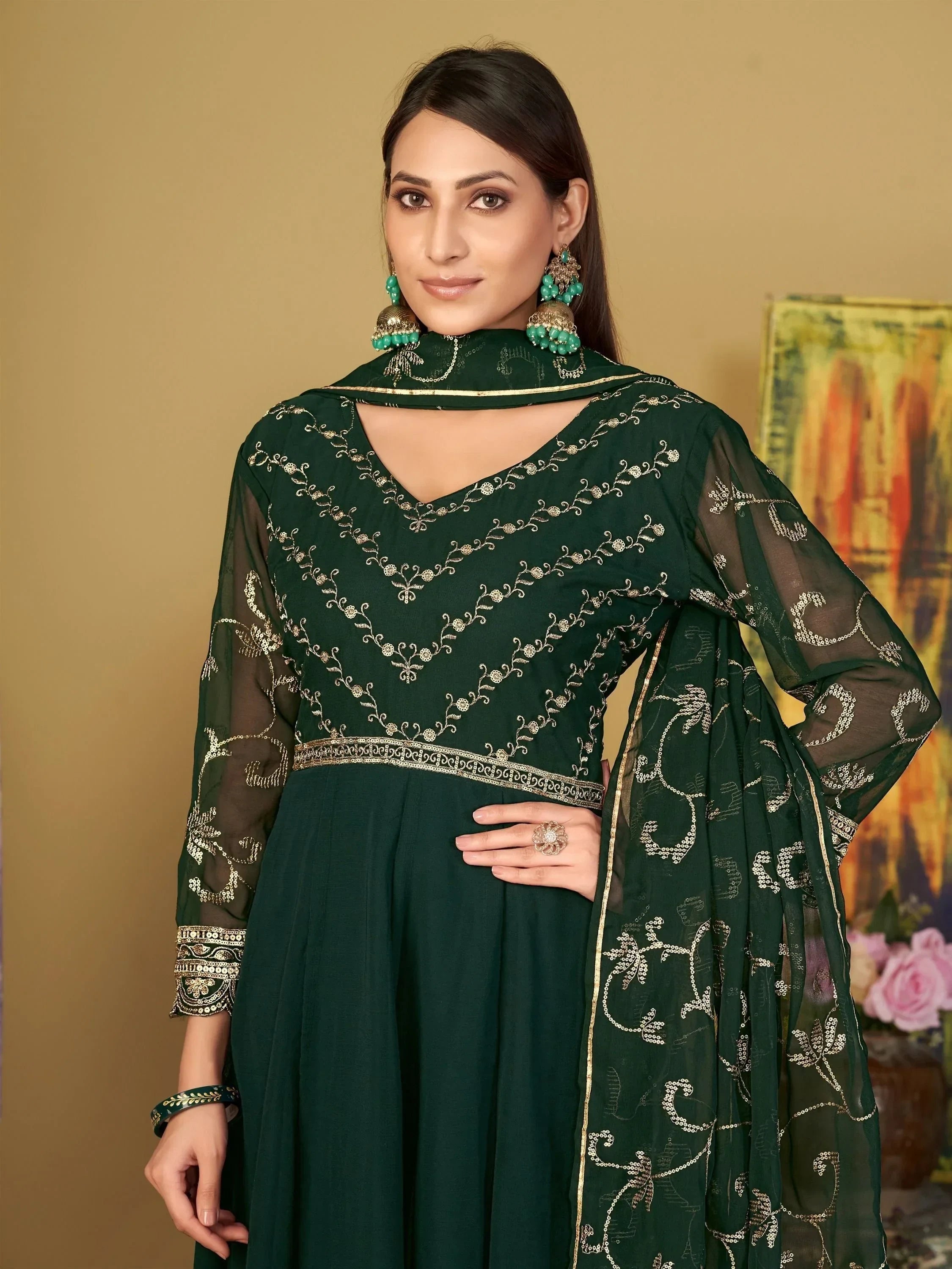 Woman wearing dark green embroidered salwar kameez with sheer sleeves and dupatta