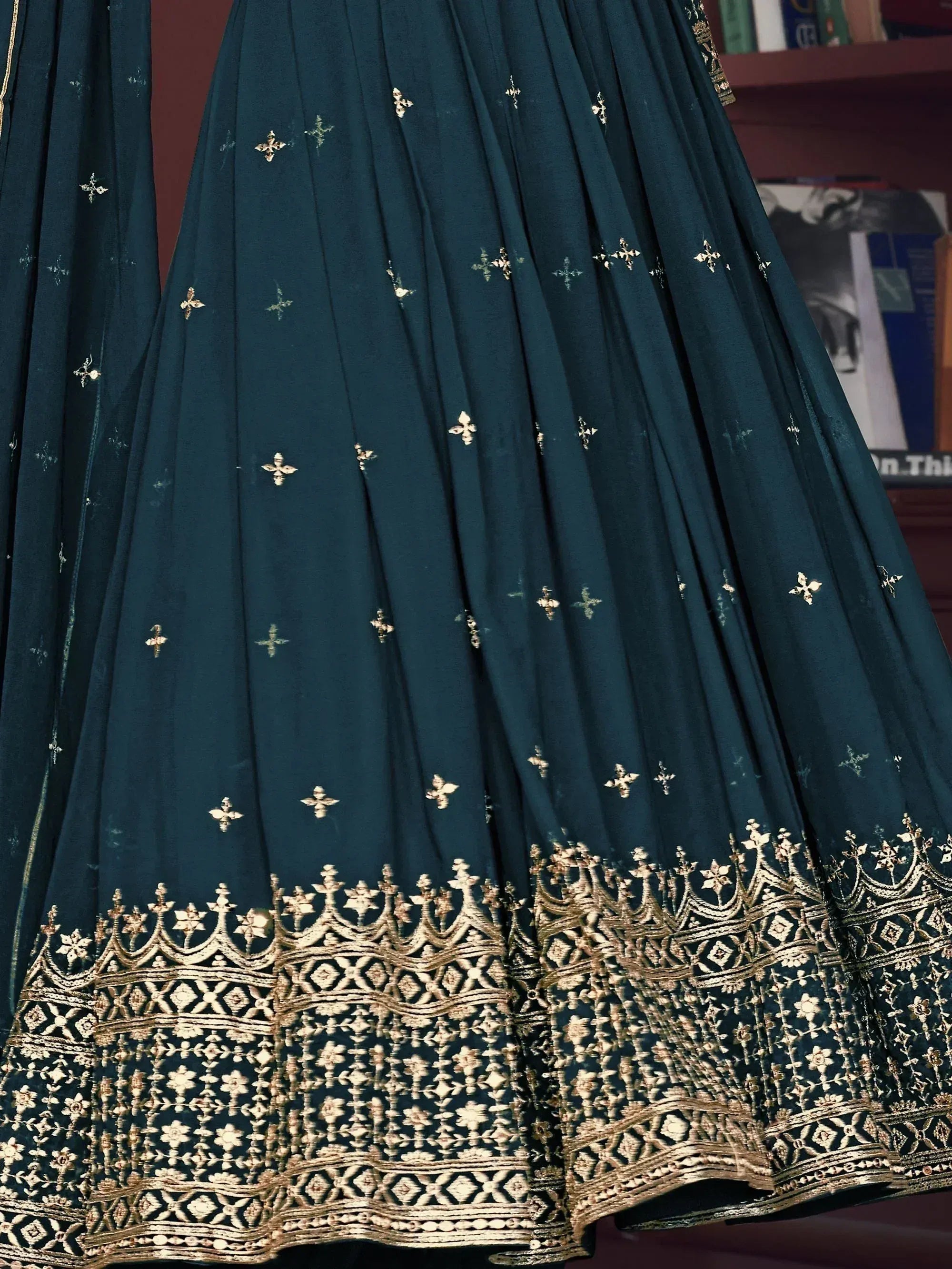 Elegant teal lehenga with gold embroidery and intricate border design