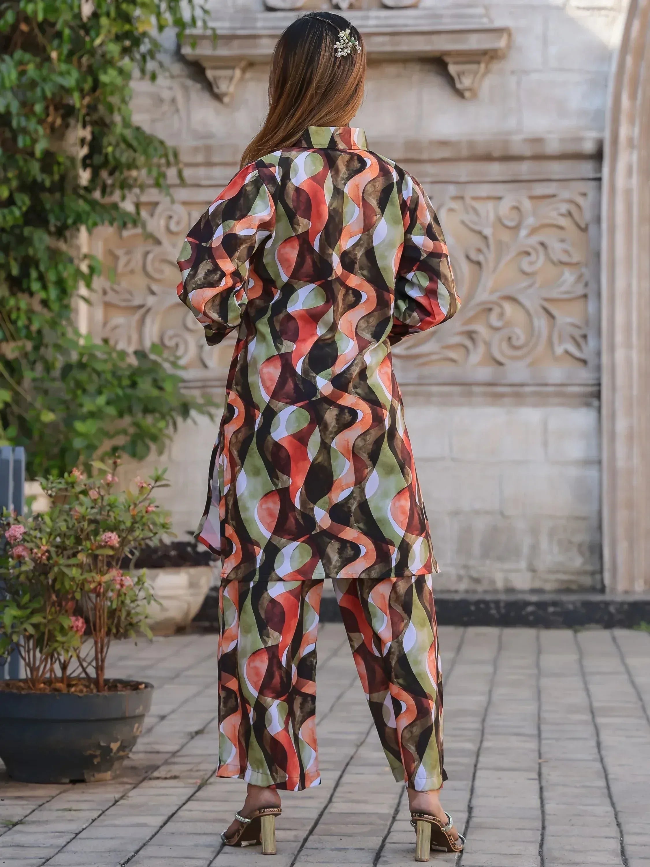 Woman in printed ethnic kurta set with wide pants, back view, garden setting