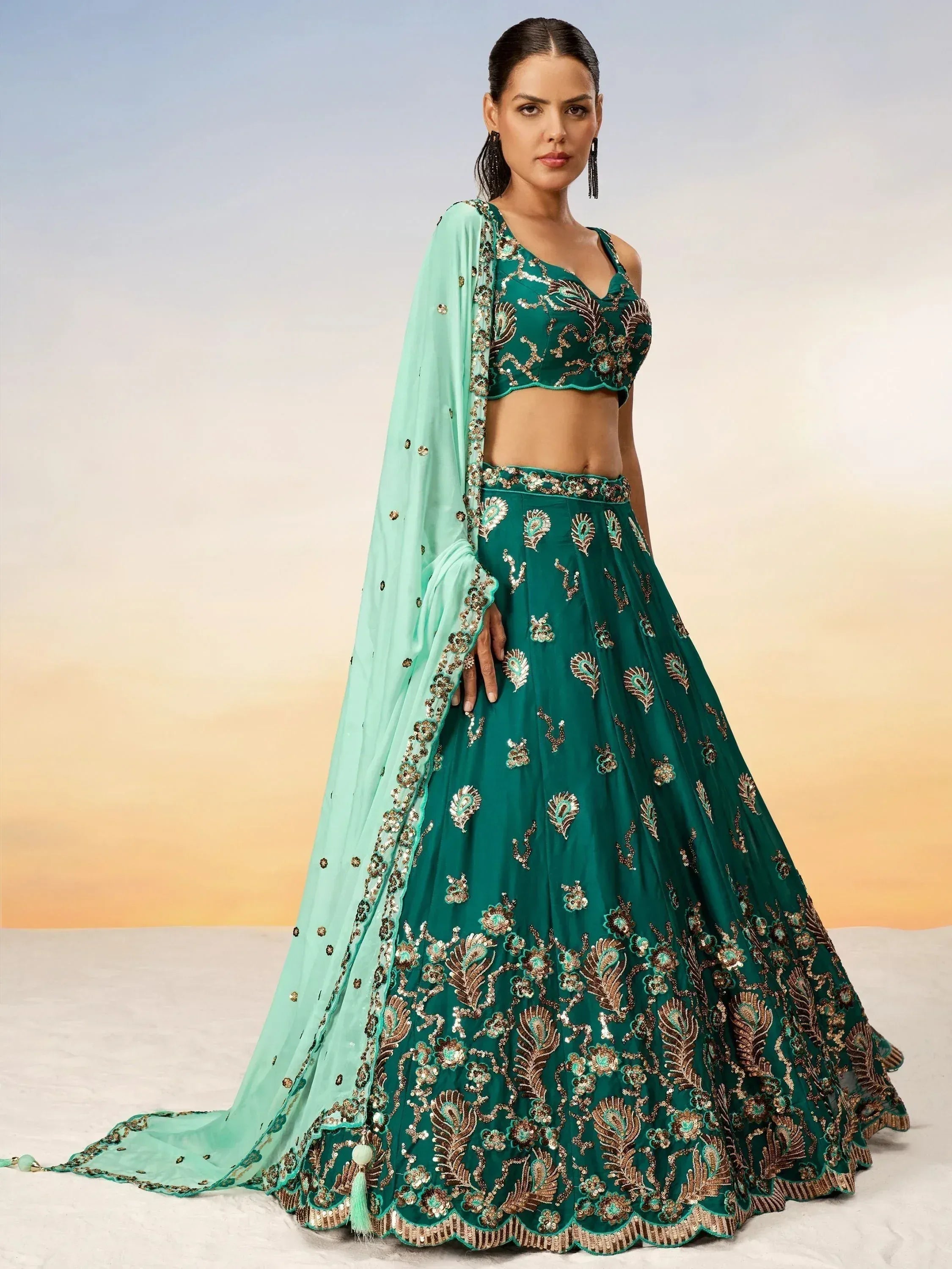 Emerald green designer lehenga choli with gold embroidery and matching dupatta, perfect for Indian ethnic occasions.