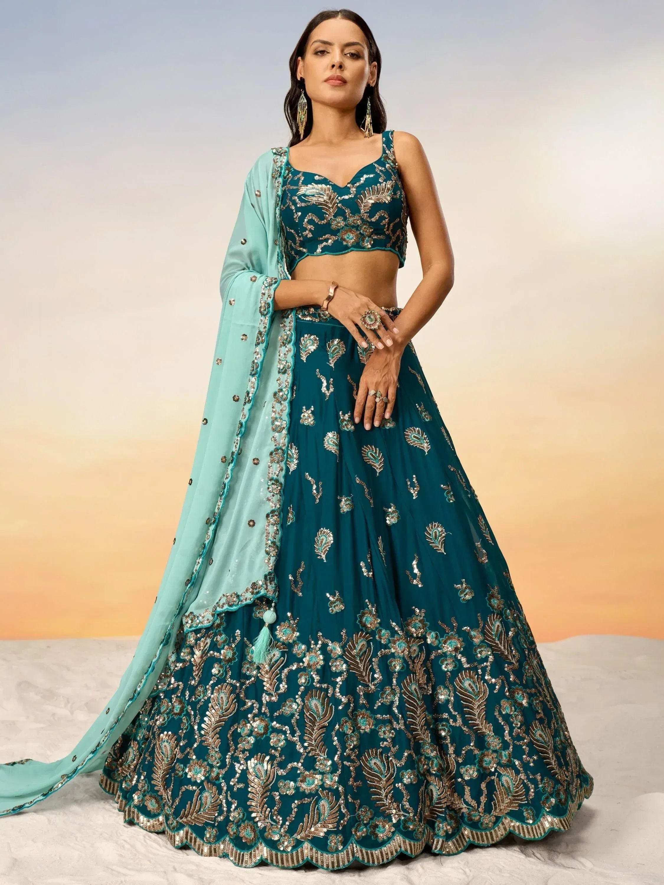Teal designer lehenga choli with gold embroidery and matching dupatta, perfect for Indian weddings and festive occasions.