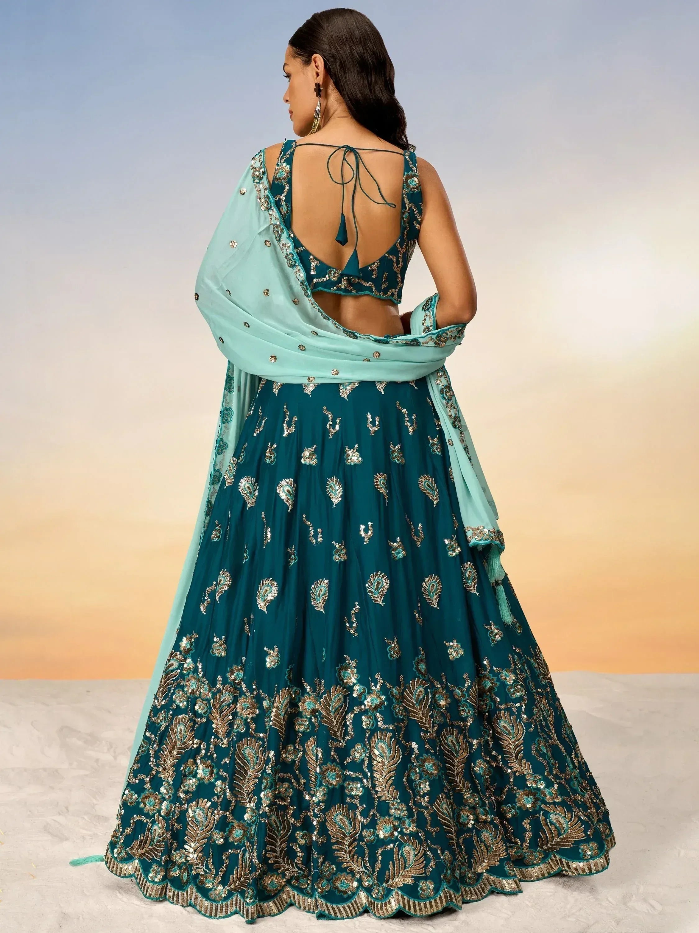 Teal designer lehenga choli with gold embroidery, backless blouse, and matching dupatta for Indian ethnic wear