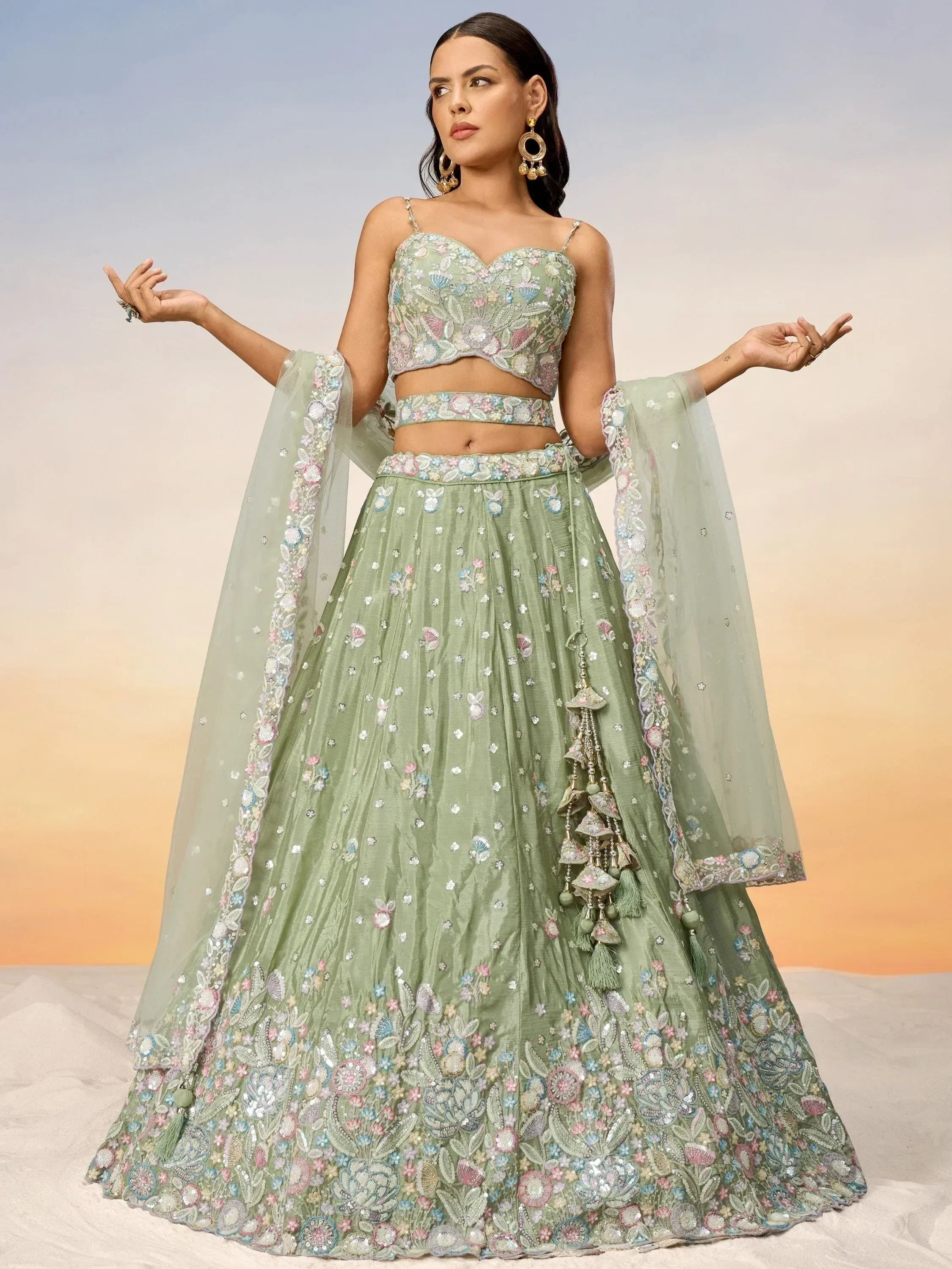 Mint green embroidered lehenga choli with floral motifs and tassels, perfect for Indian weddings or festive occasions.