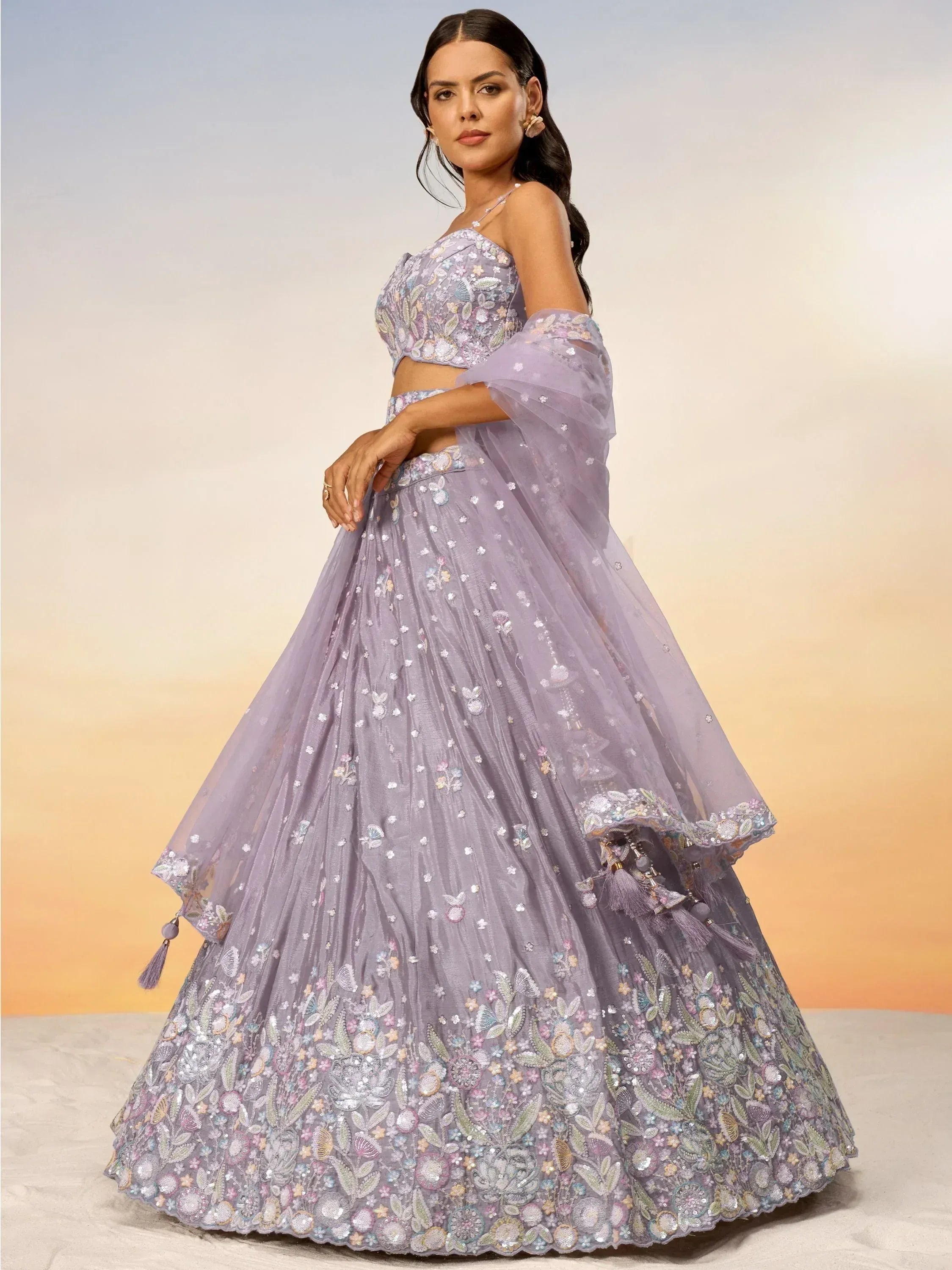 Lavender designer lehenga choli with floral embroidery and tassels, perfect for Indian ethnic wear occasions.