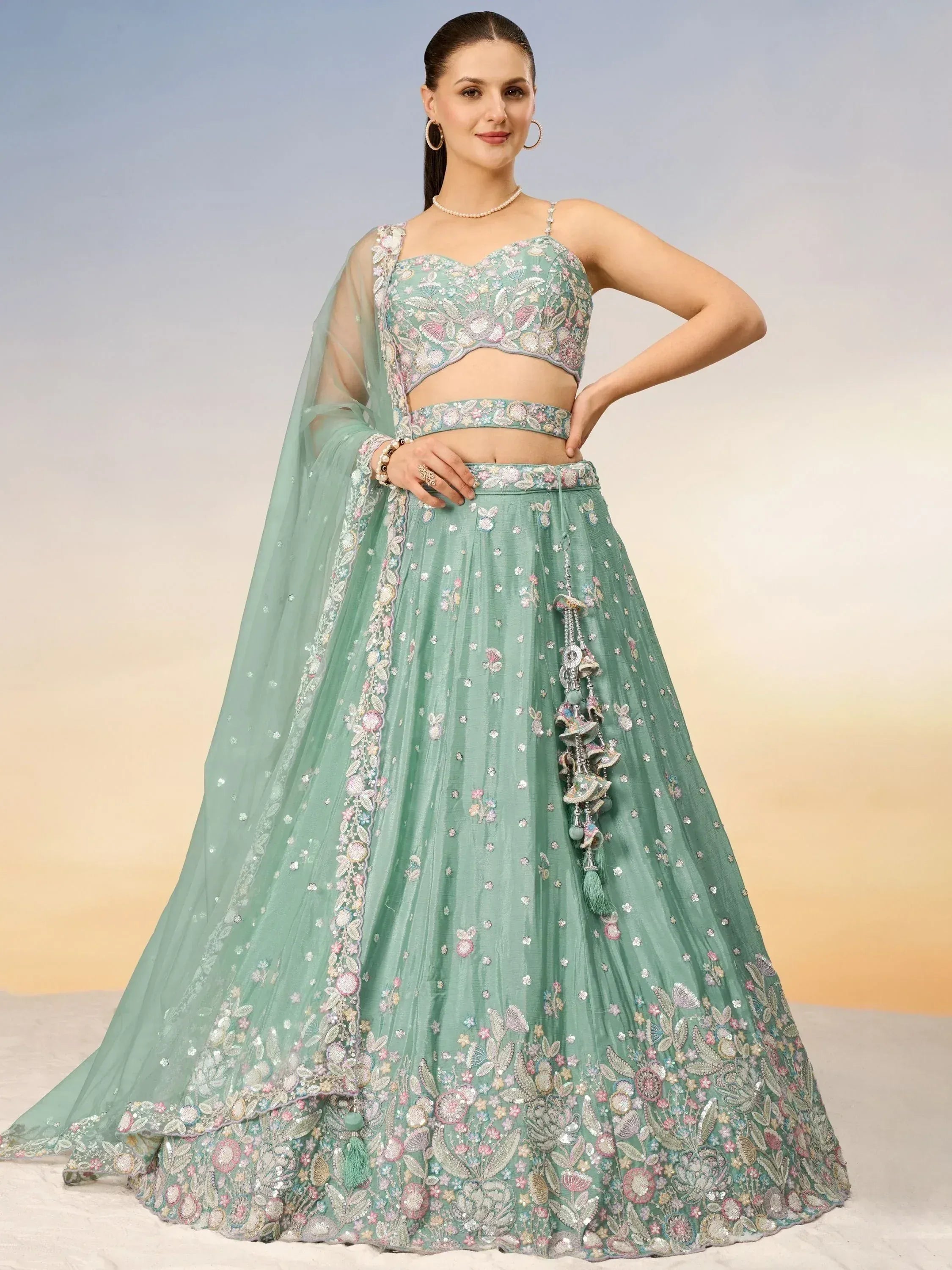 Mint green embroidered lehenga choli with floral motifs and tassels, perfect for Indian ethnic occasions.