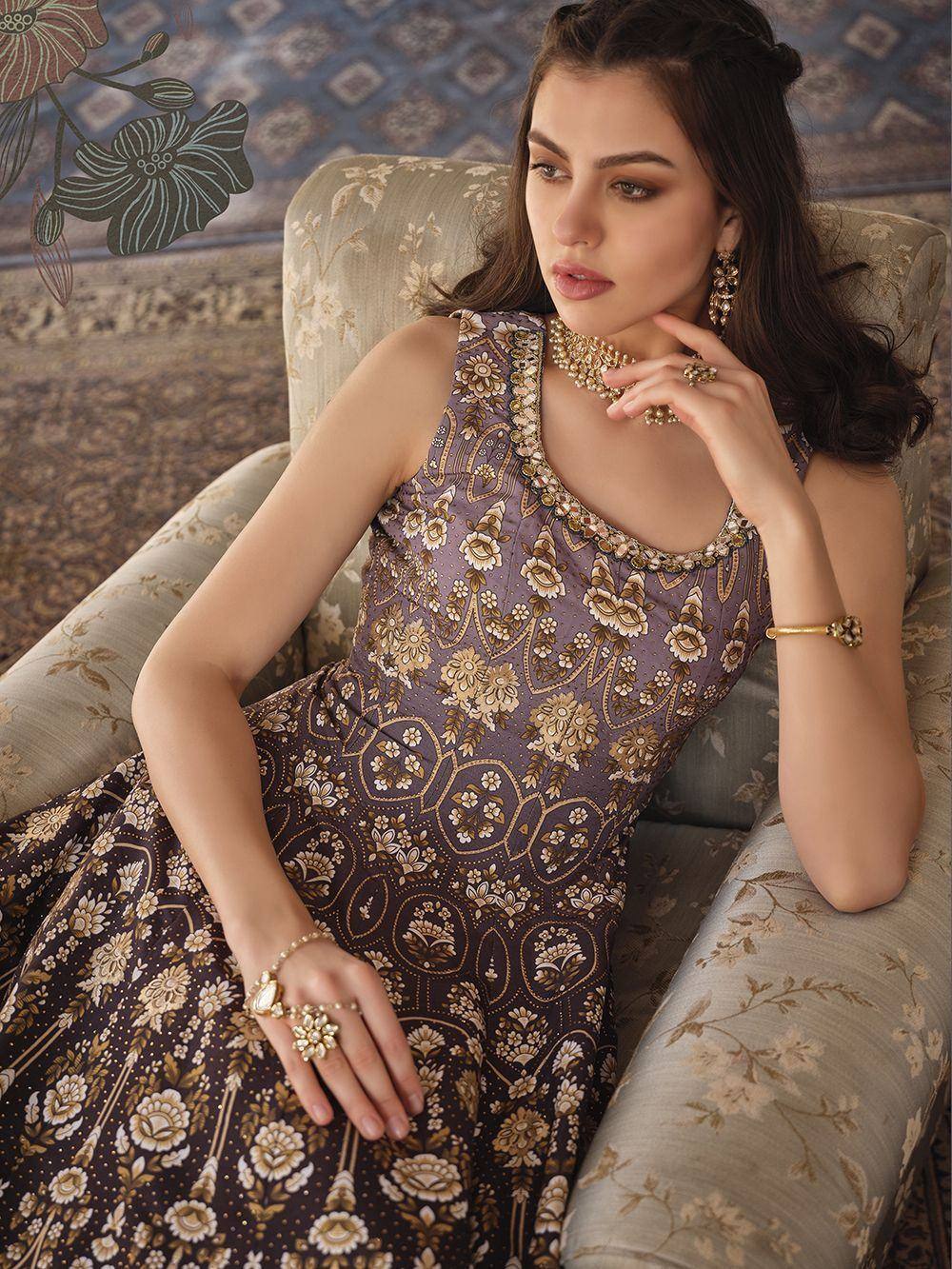 Elegant purple floral ethnic gown with gold embroidery, paired with traditional jewelry for festive occasions.