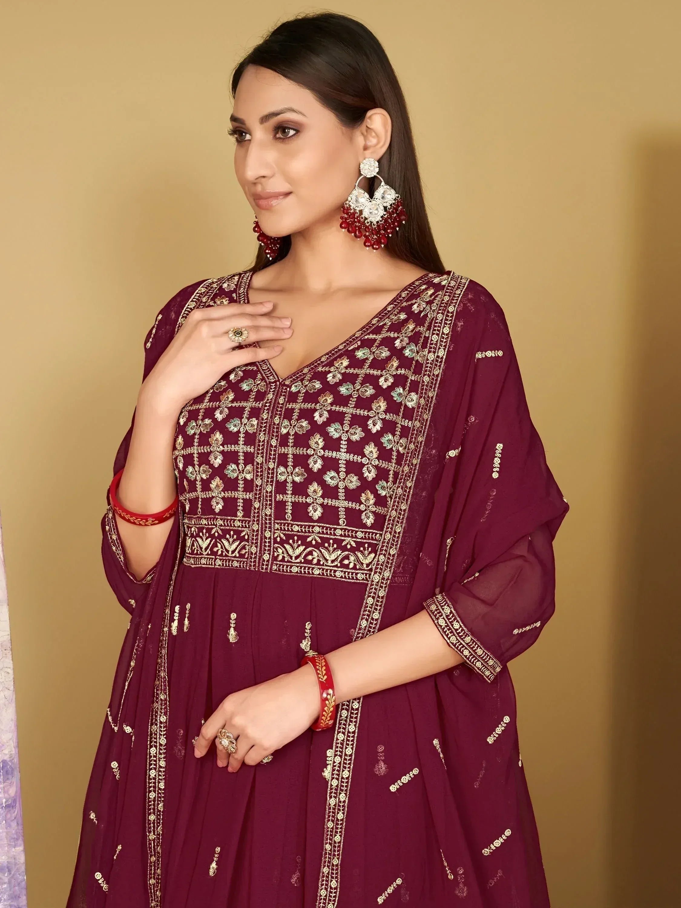 Maroon embroidered ethnic gown with gold detailing, perfect for Indian festive occasions and weddings