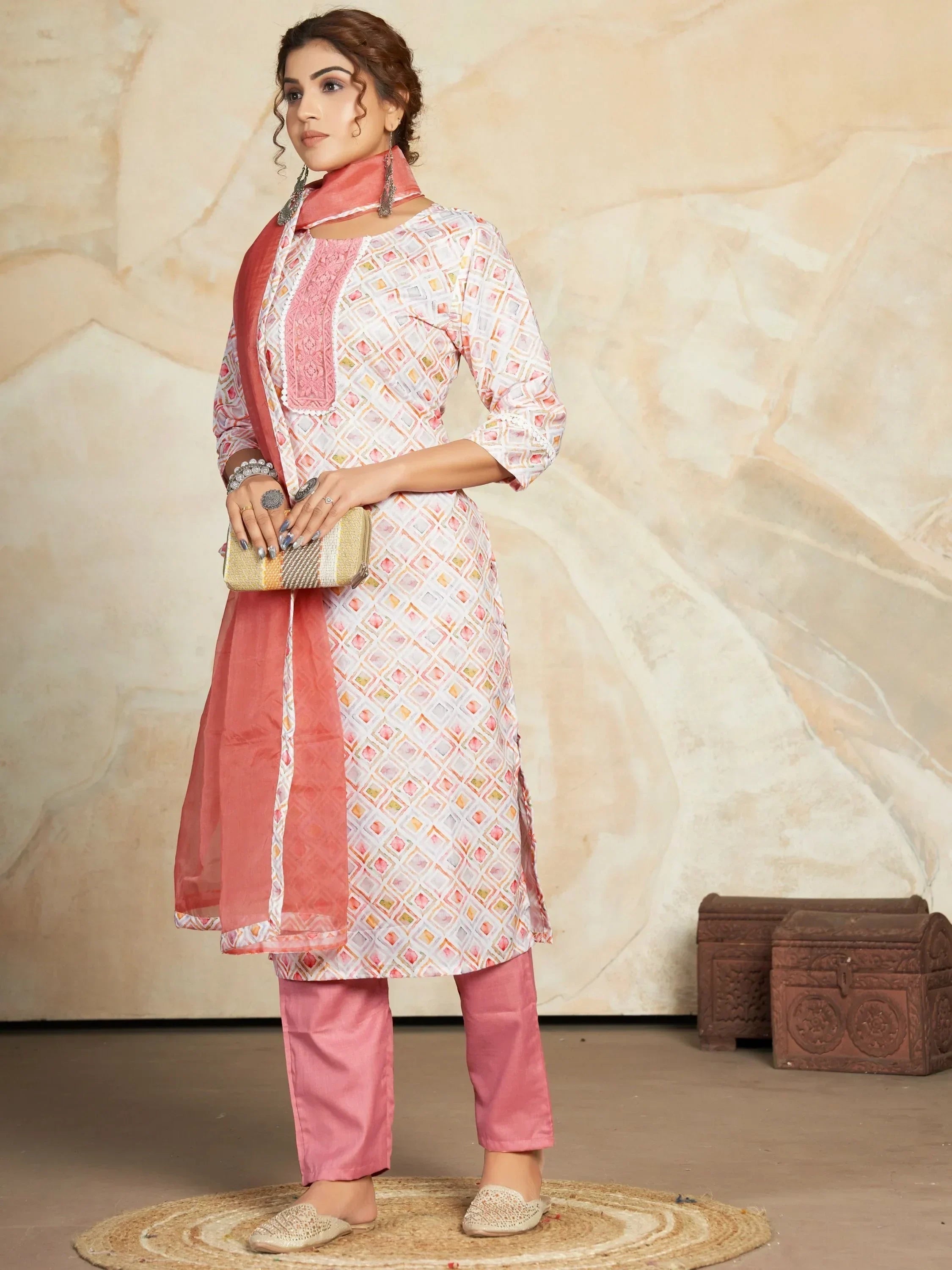 Woman wearing pink printed salwar kameez with matching dupatta and clutch, ethnic fashion