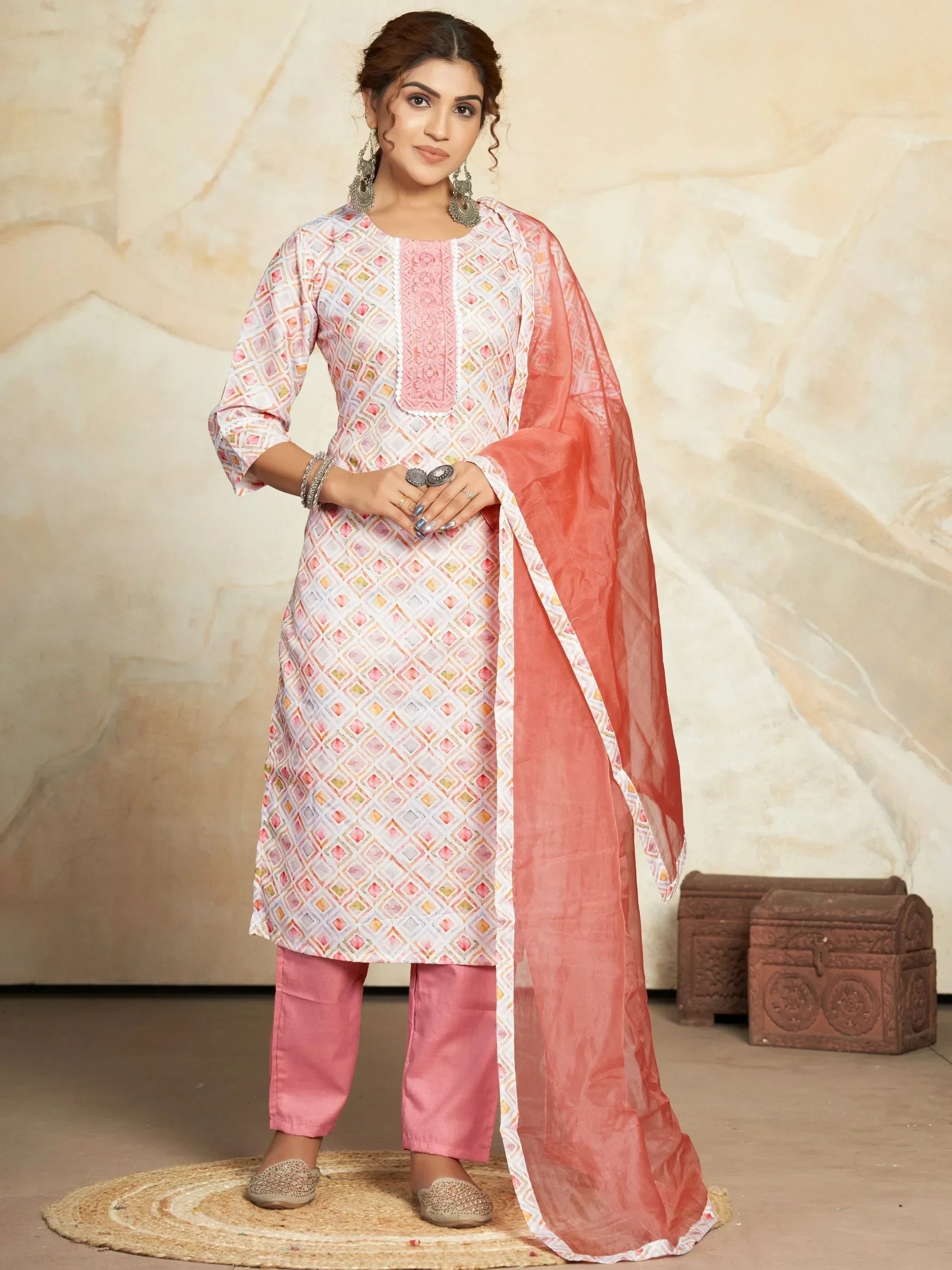 Woman in pink and white printed salwar kameez with matching dupatta and ethnic jewelry
