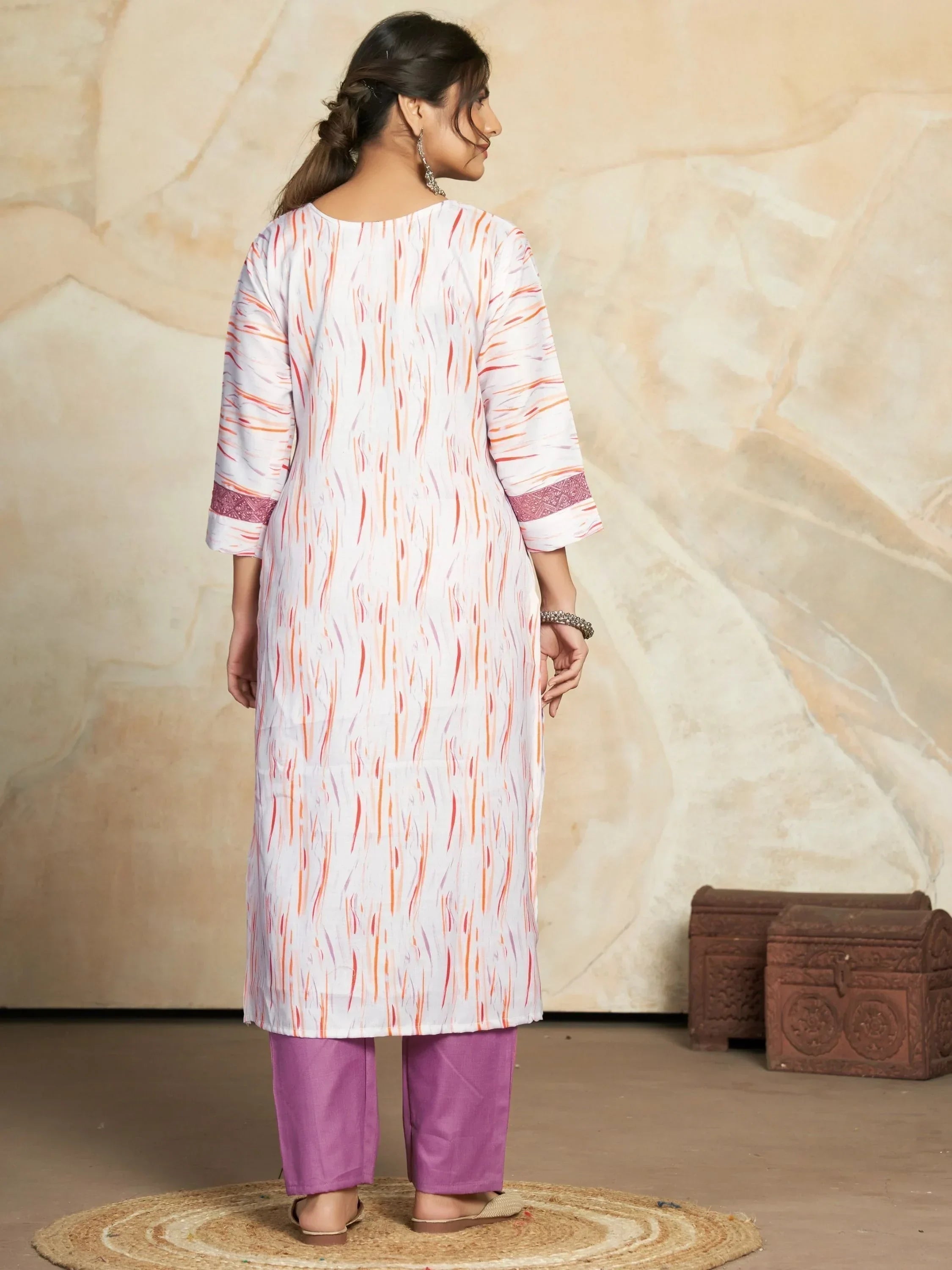 Woman wearing white printed kurta with three-quarter sleeves and lavender pants, back view