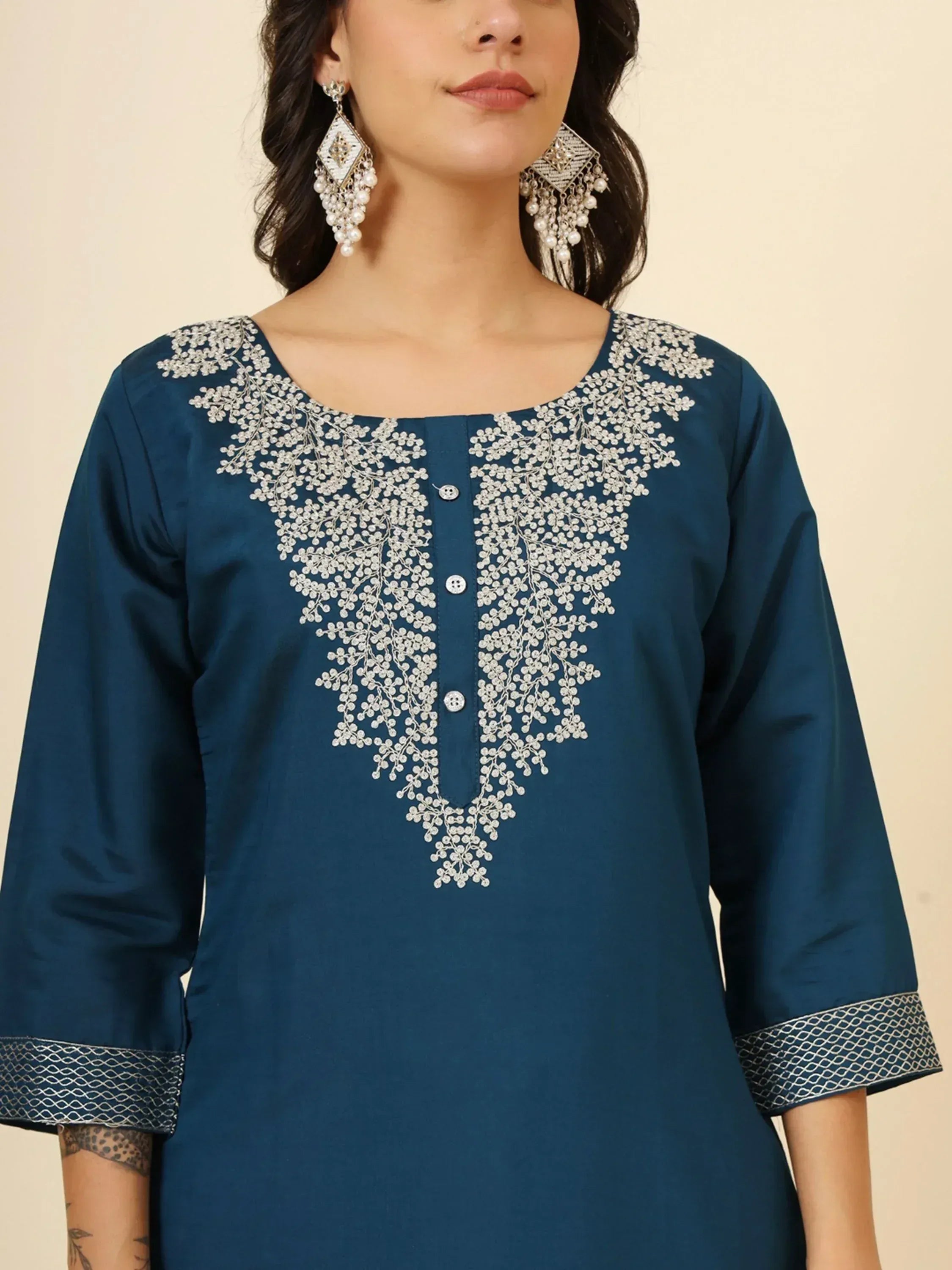 Teal ethnic kurti with floral embroidery and pearl embellishments, paired with statement earrings