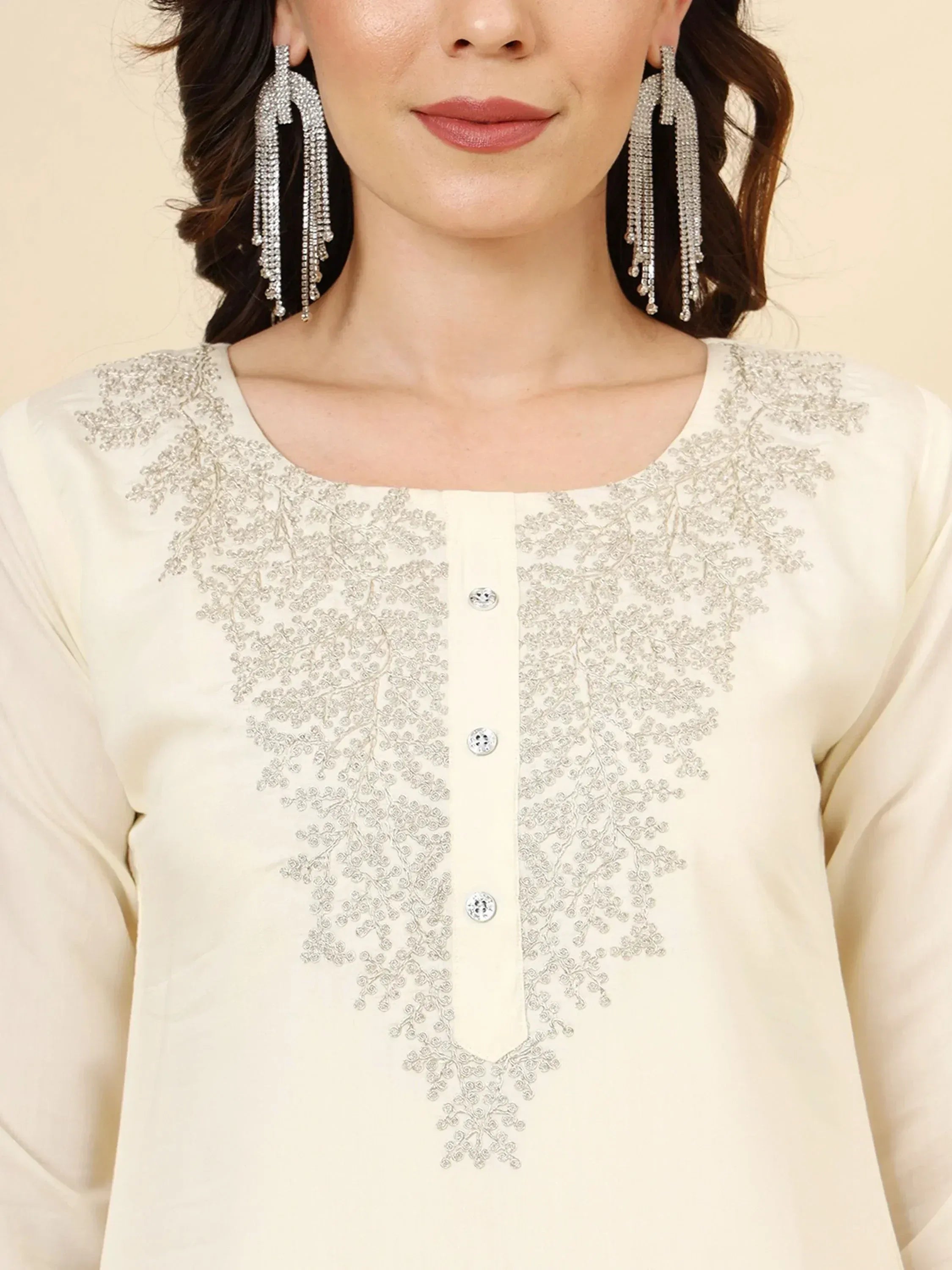 Cream embroidered kurta with silver threadwork and matching dangling earrings for ethnic wear