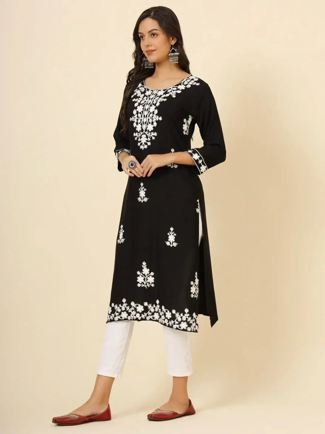 Black kurta with white floral embroidery, paired with white pants and red flats, ethnic wear style