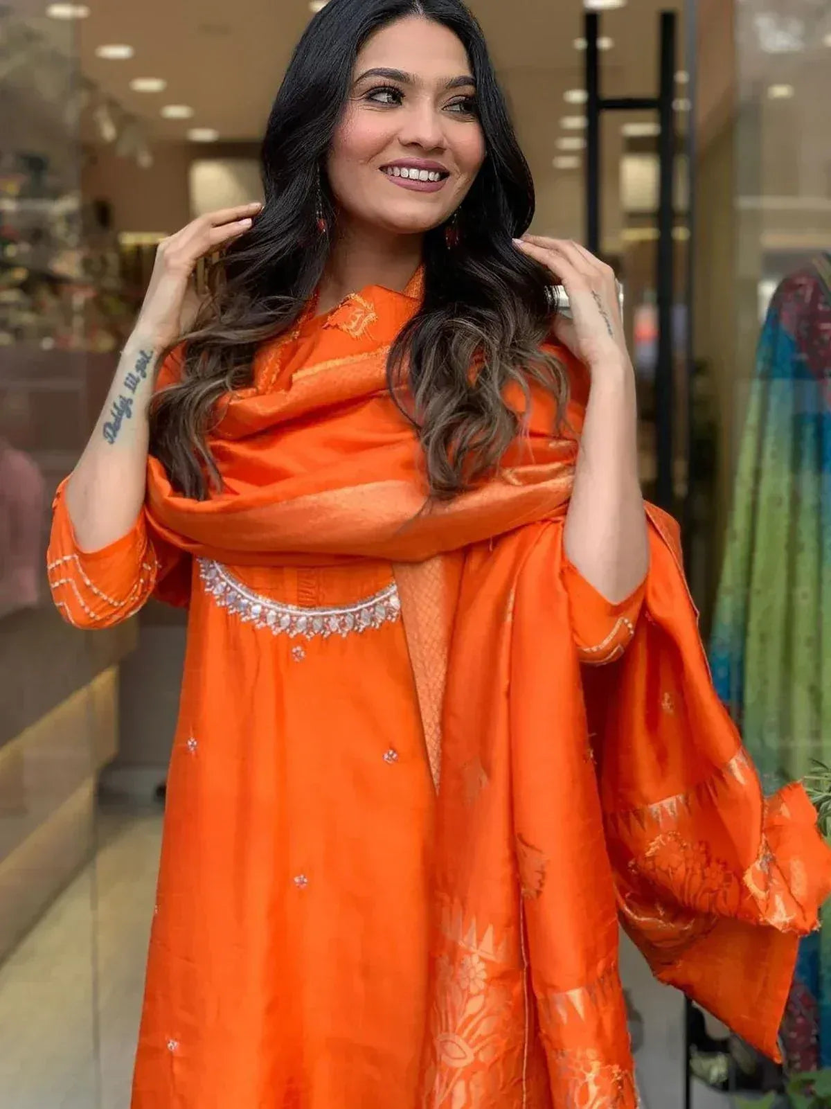 Vibrant orange ethnic salwar kameez with embellished neckline and matching dupatta, perfect for festive occasions.