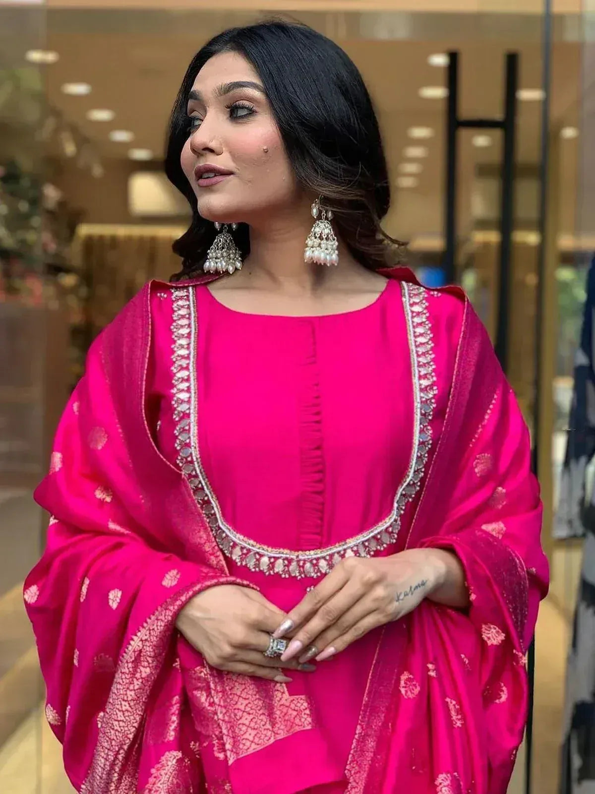 Vibrant pink ethnic salwar kameez with silver embroidery and matching dupatta, styled with jhumka earrings